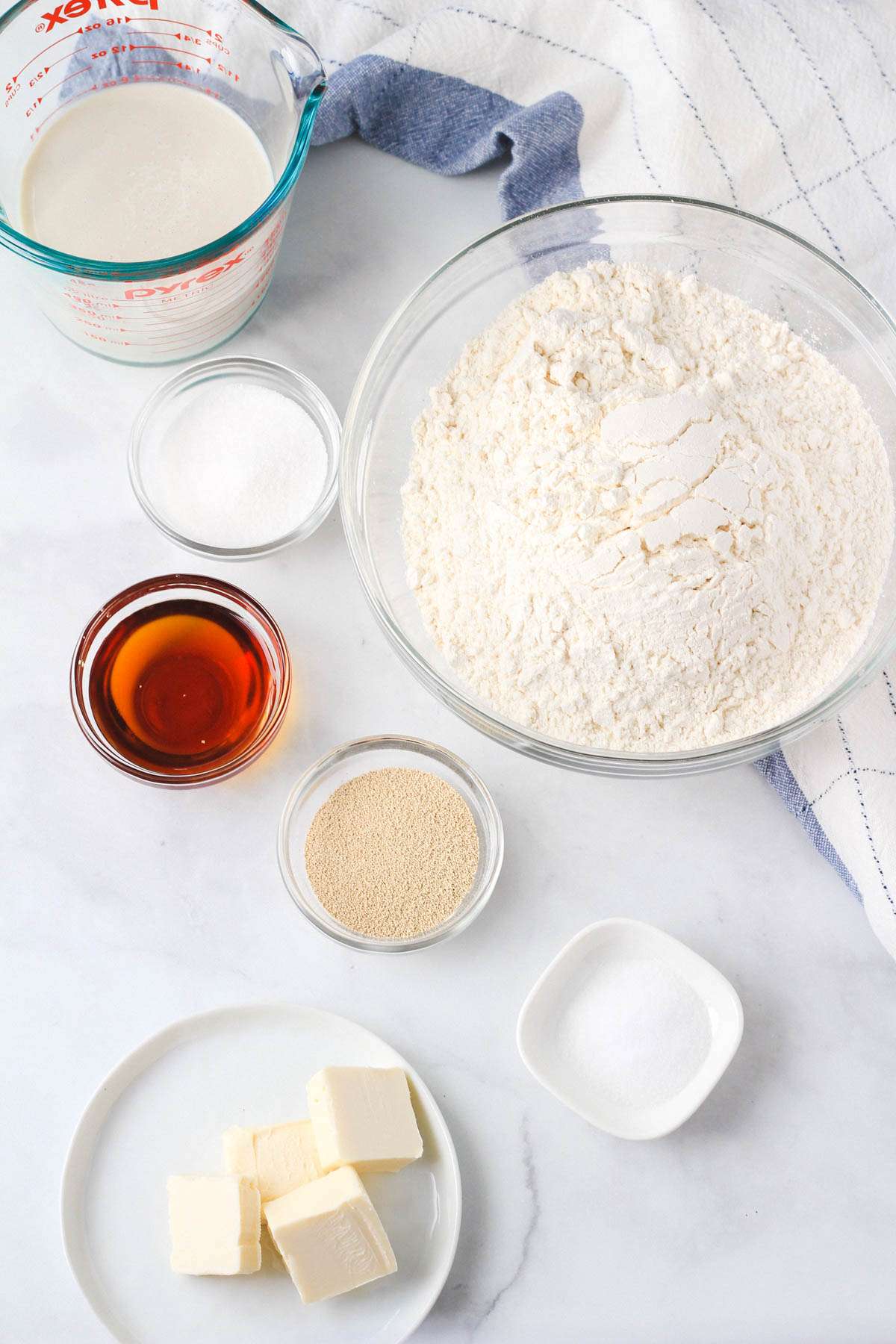 Ingredients for vegan dinner rolls on a white counter.