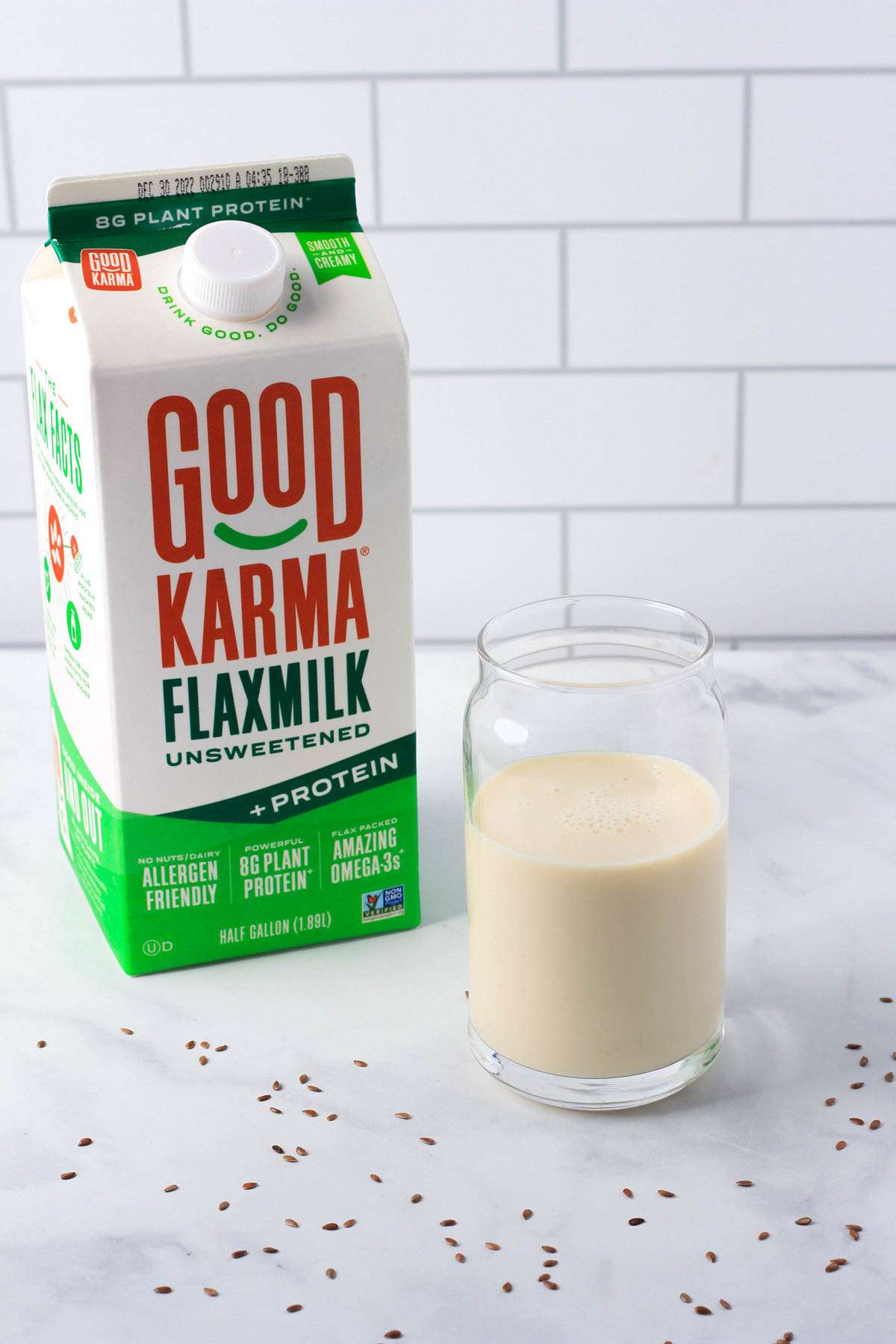 A carton of flax milk on the left with a glass of flax milk in the middle for a dairy-free milk guide post.