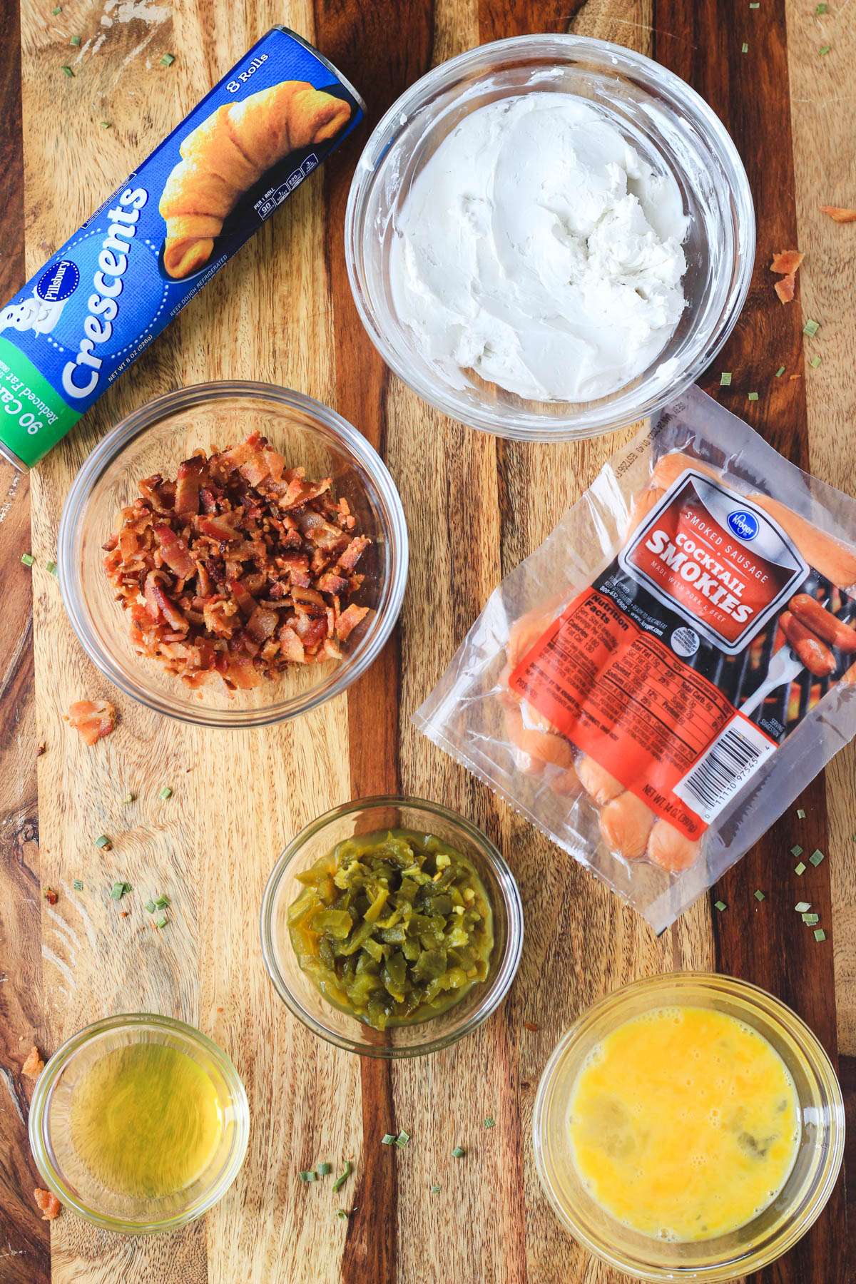 Ingredients for jalapeño popper pigs in a blanket on a wooden counter.