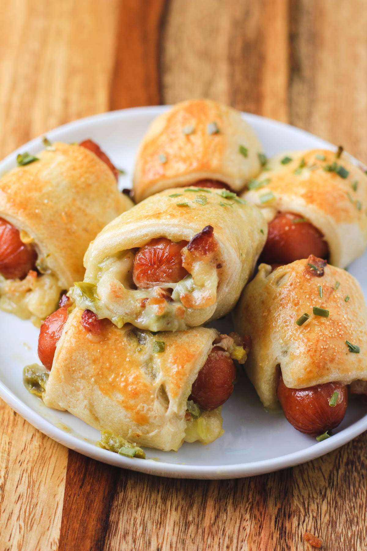 A small white plate topped with baked dairy-free jalapeño popper pigs in a blanket.