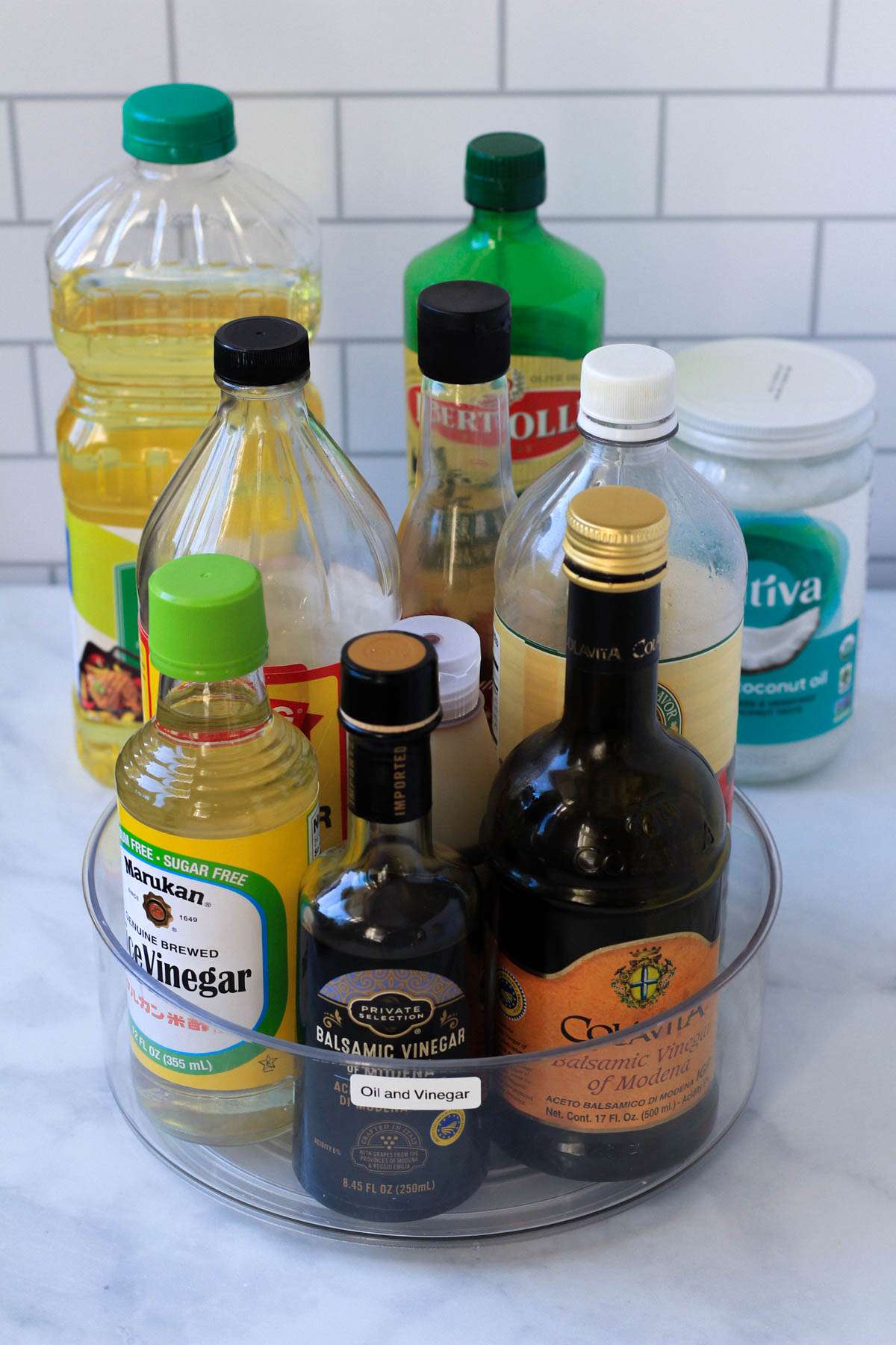 Oils and vinegars for pantry-staple ingredients on a white counter.
