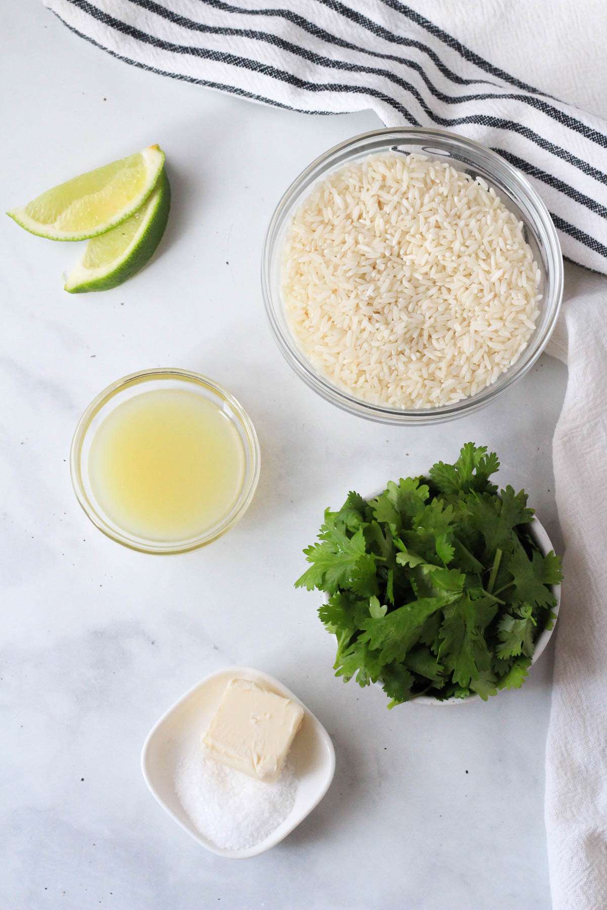 Ingredients for cilantro lime rice on a white counter.