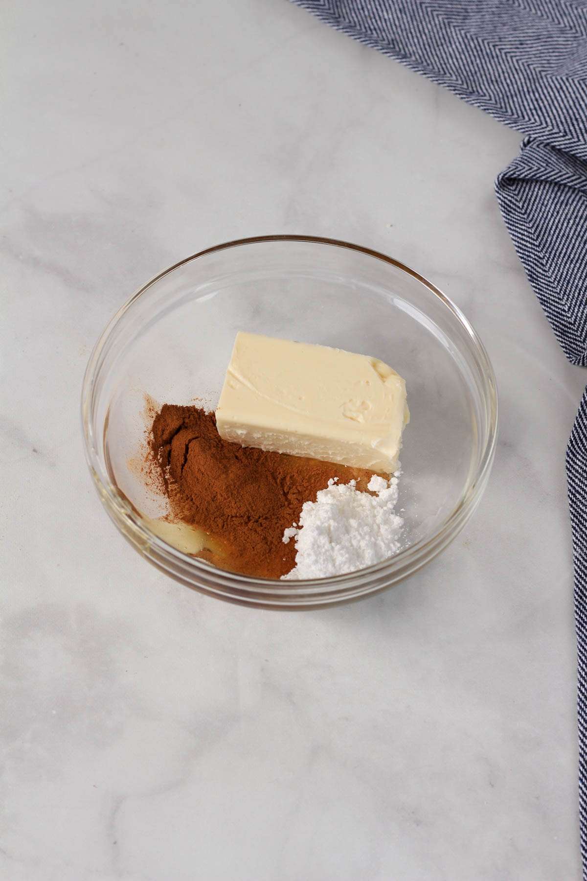 A small glass bowl with the ingredients for cinnamon honey butter before mixing together.
