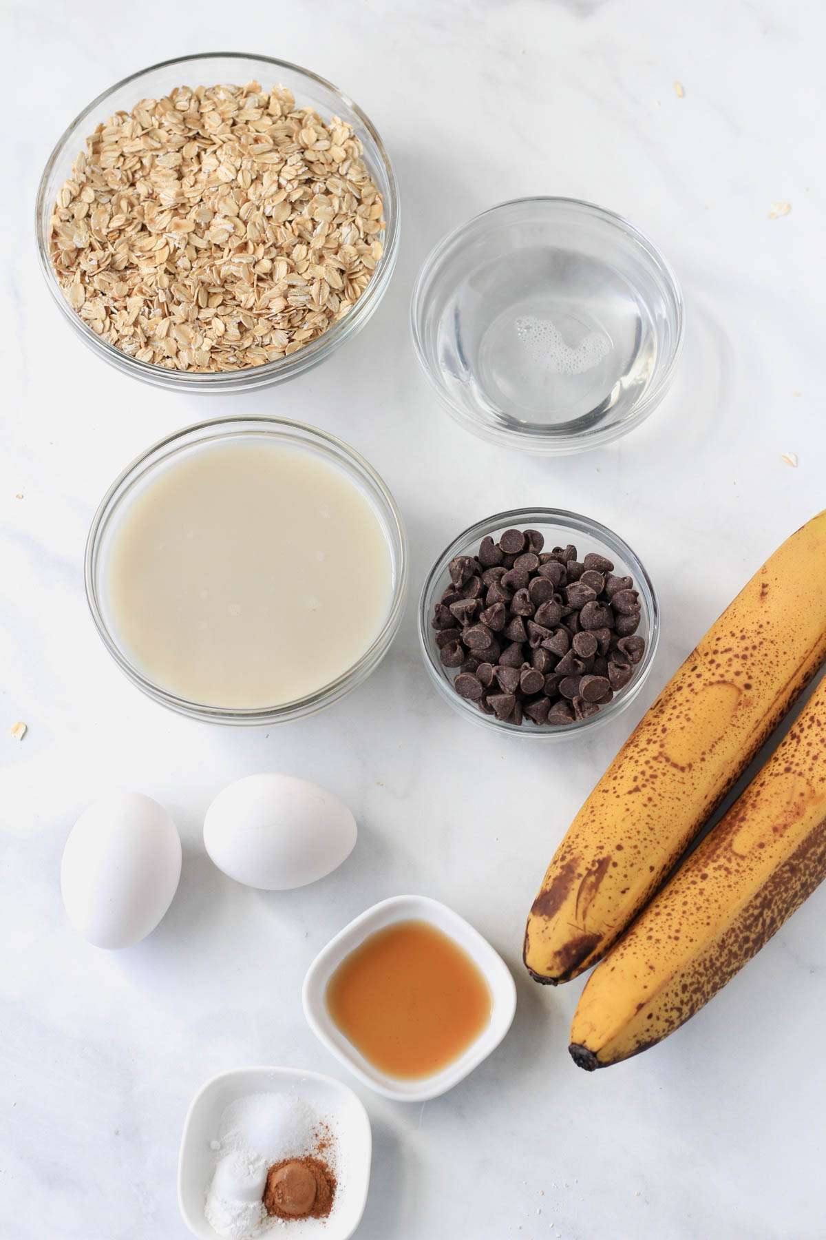 Ingredients for banana baked oatmeal on a white counter.