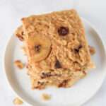 A top down picture of a square of baked oatmeal topped with banana and chocolate chips.