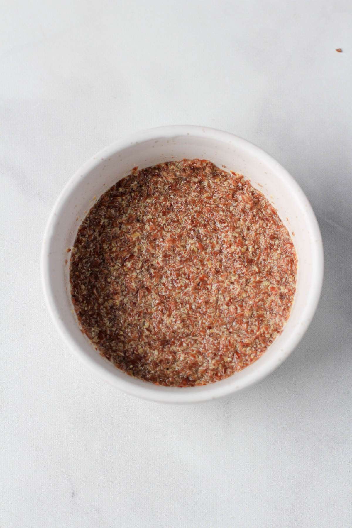 A small white bowl with ground flax and water mixed together.