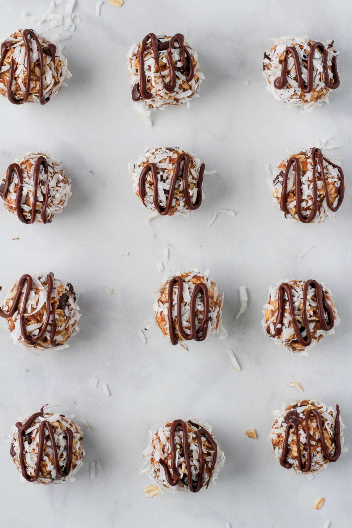 Rows of healthy almond joy lactation bites topped with drizzled vegan chocolate.
