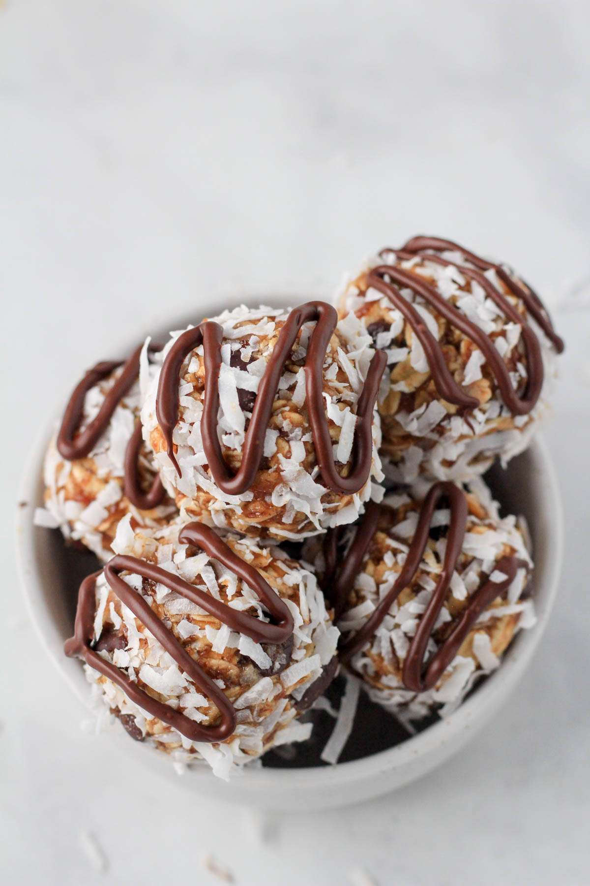 A small white bowl with vegan almond joy lactation bites.