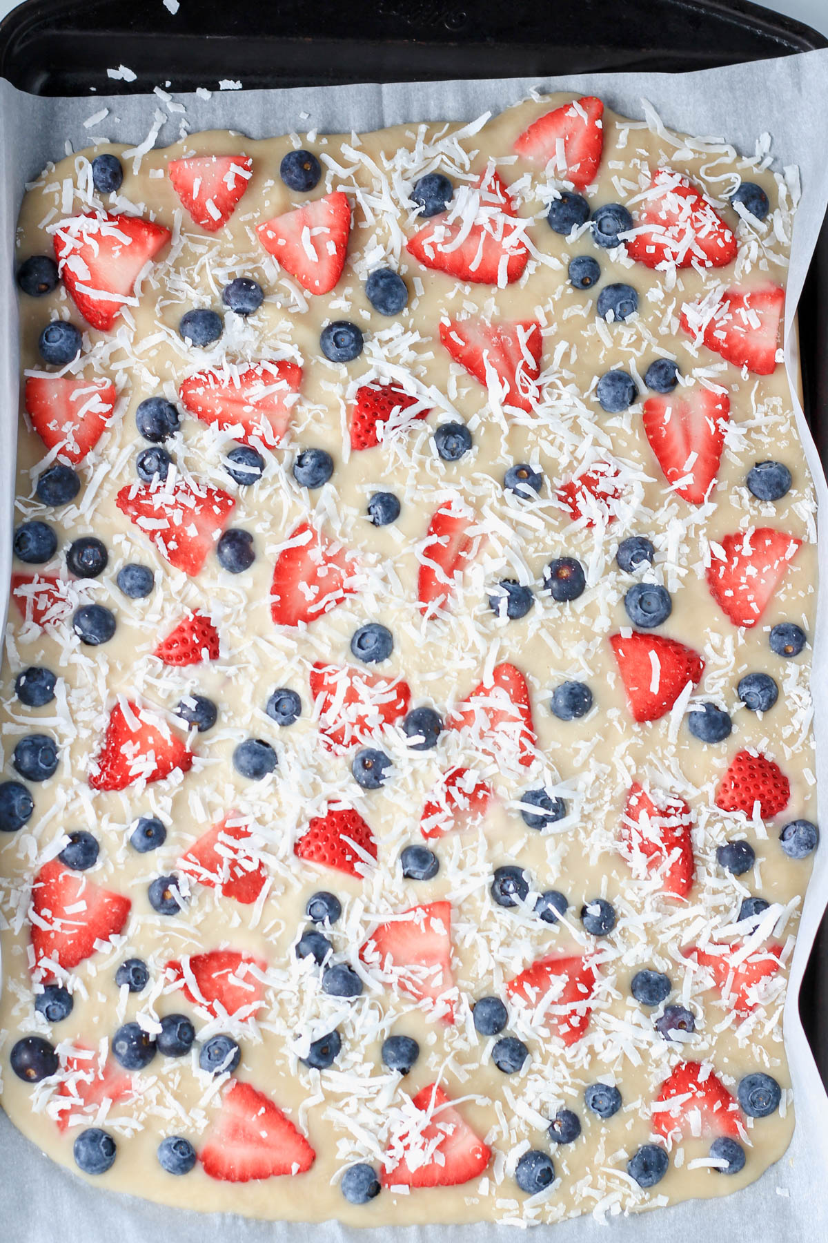 Vegan frozen yogurt bark on a parchment paper lined baking sheet after freezing.