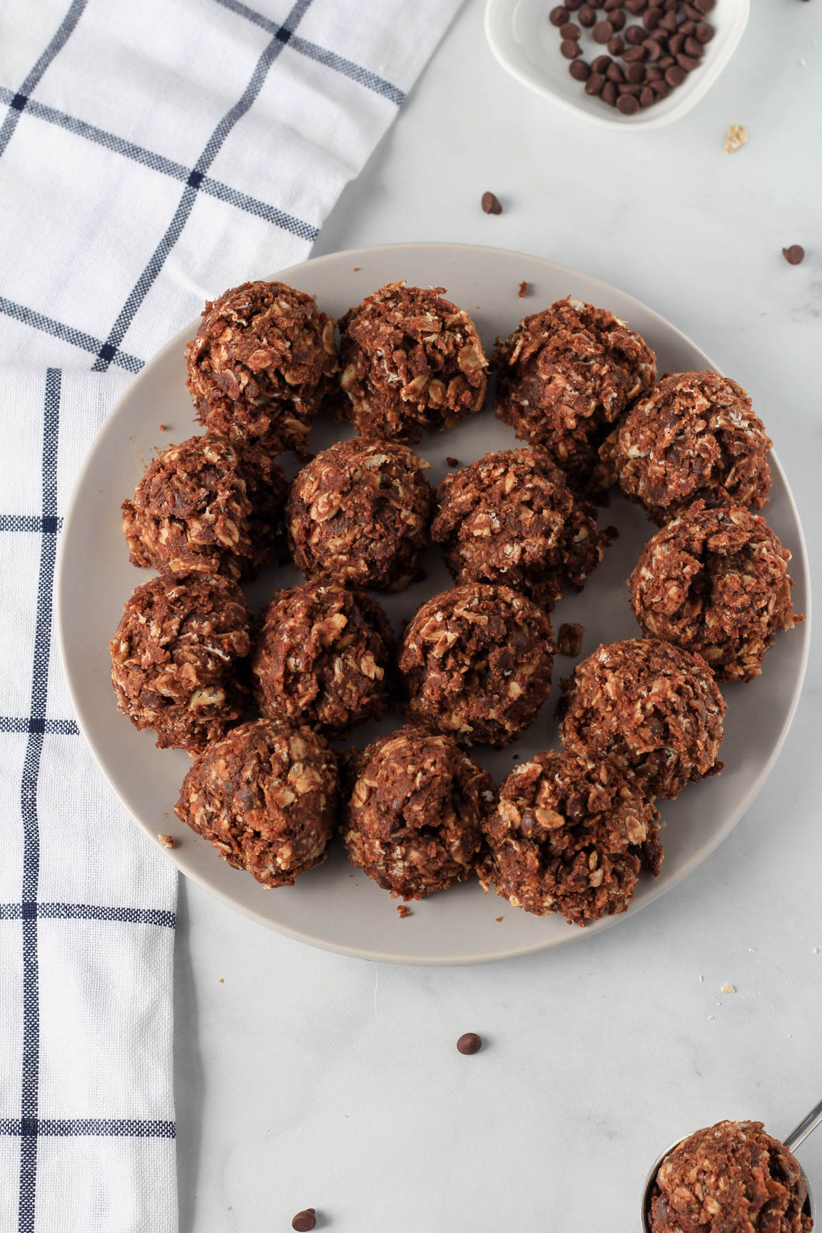 A small grey plate topped with scoops of chocolate almond lactation bites before rolling together into balls.