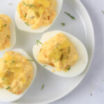 A small white plate topped with dill pickle deviled eggs.
