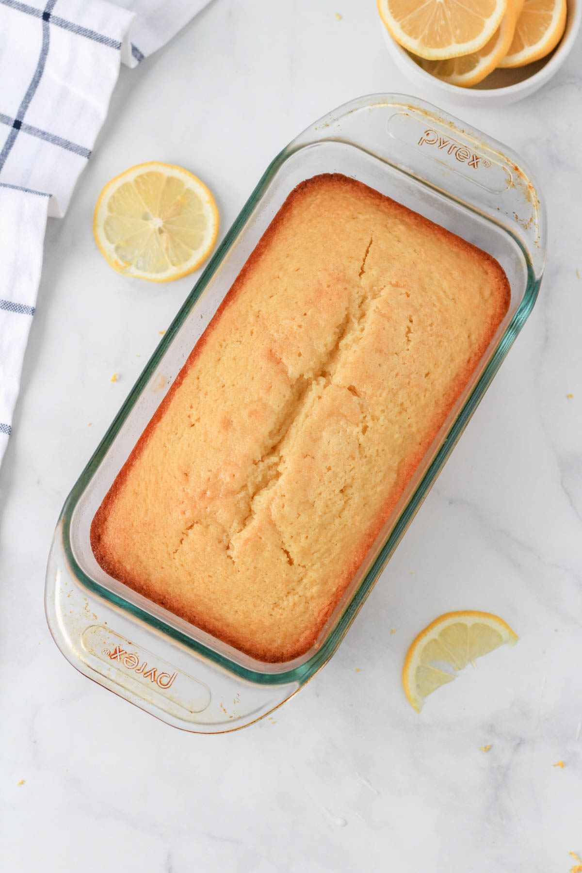 A glass loaf pan with the baked lemon loaf before icing.