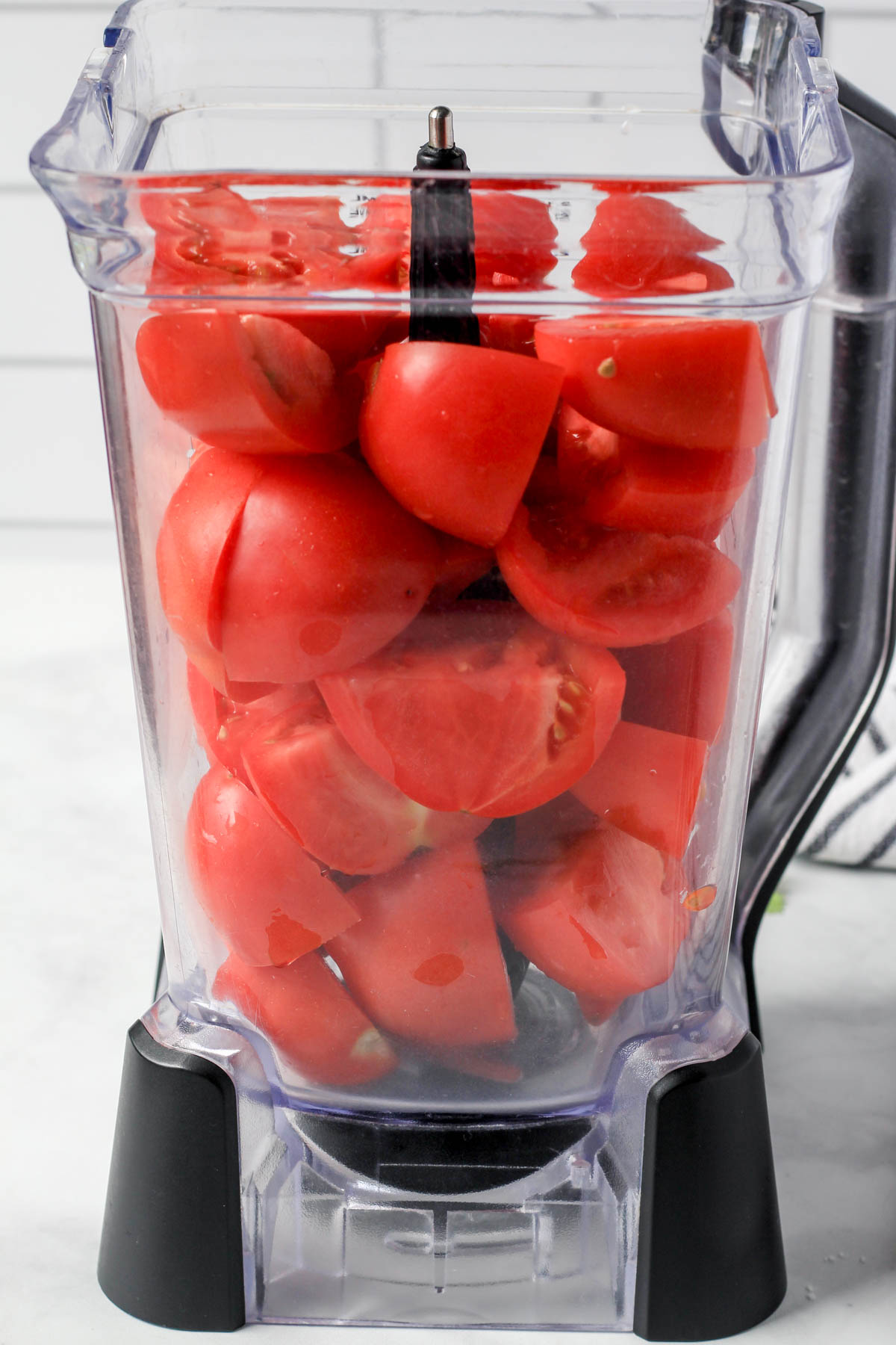A blender filled with roma tomatoes before they are blended.