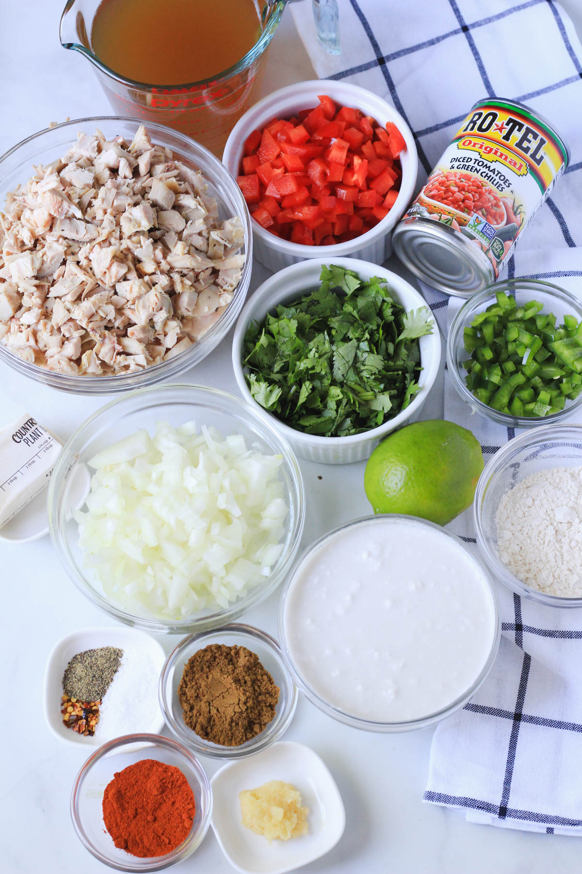 Ingredients for dairy-free king ranch casserole on a white counter with a blue and white dish towel.