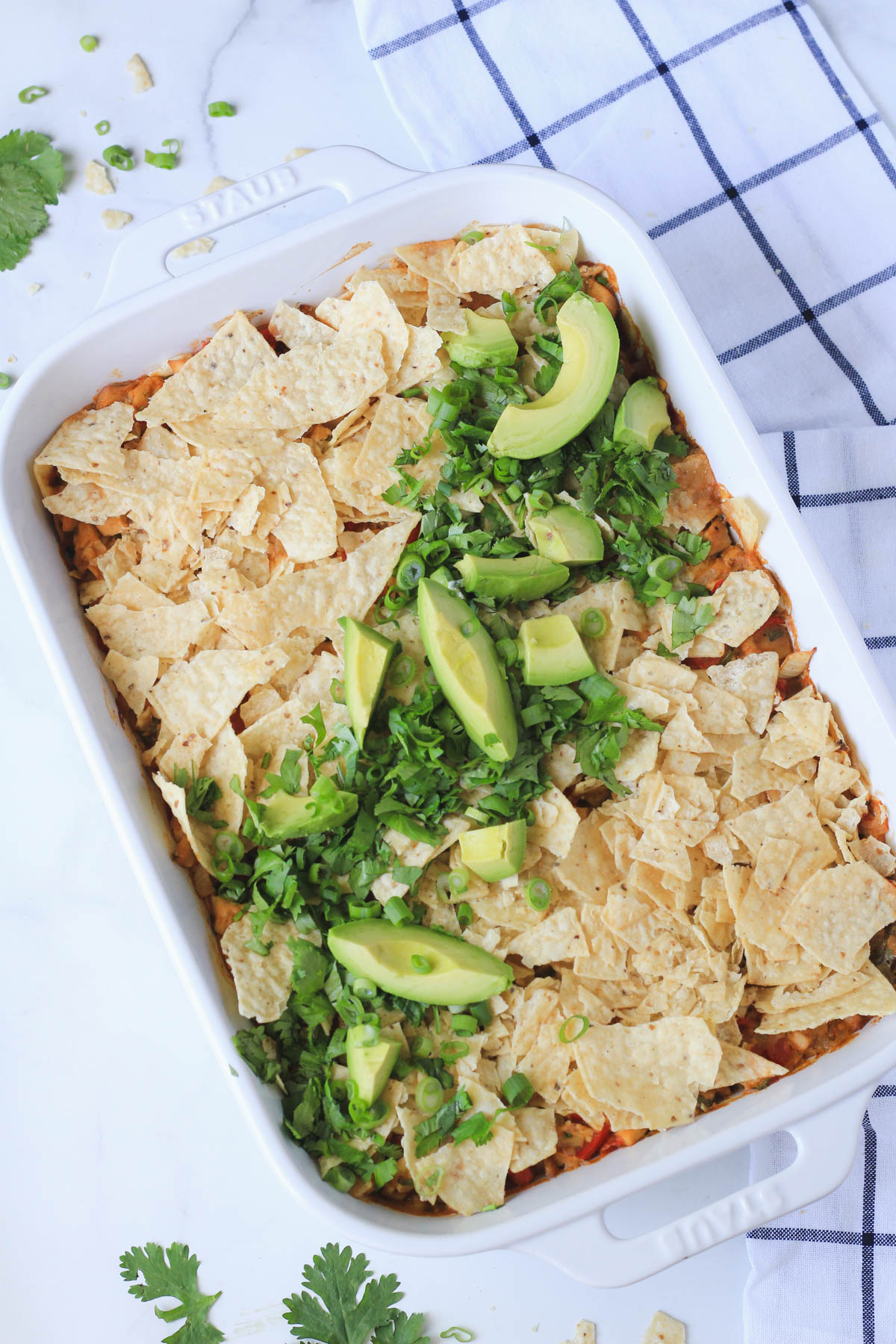A fully baked dairy-free king ranch casserole topped with cilantro, avocado, and green onion.