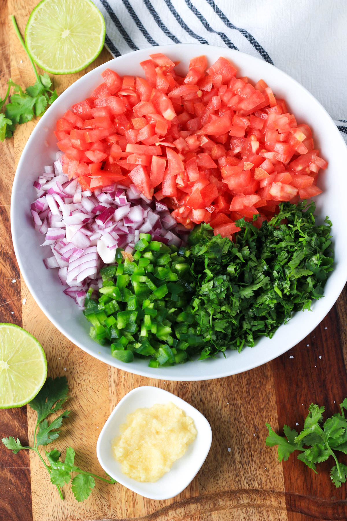 Diced vegetables in a white bowl on a wooden counter.