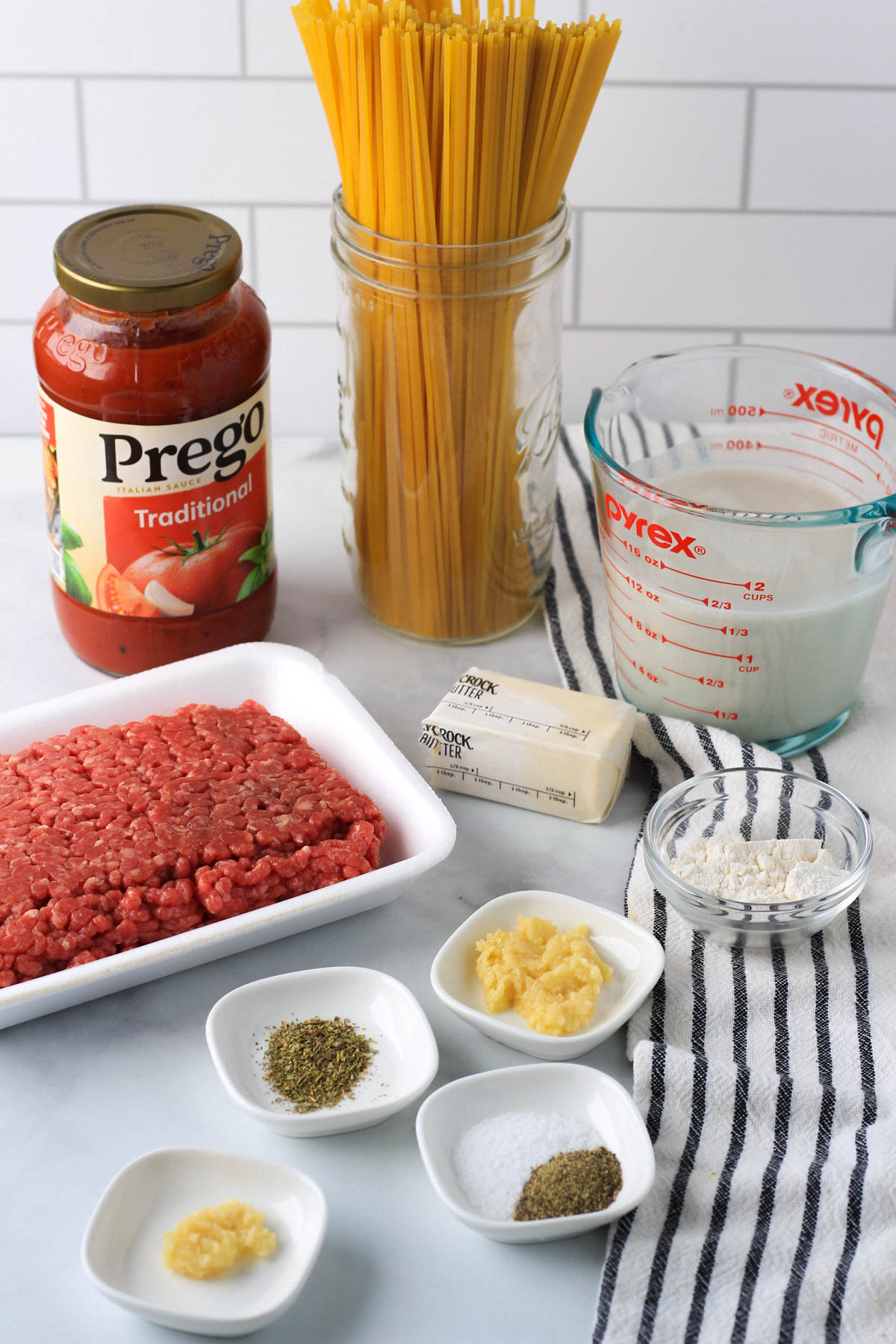 Ingredients on a white counter for the red and white pasta.
