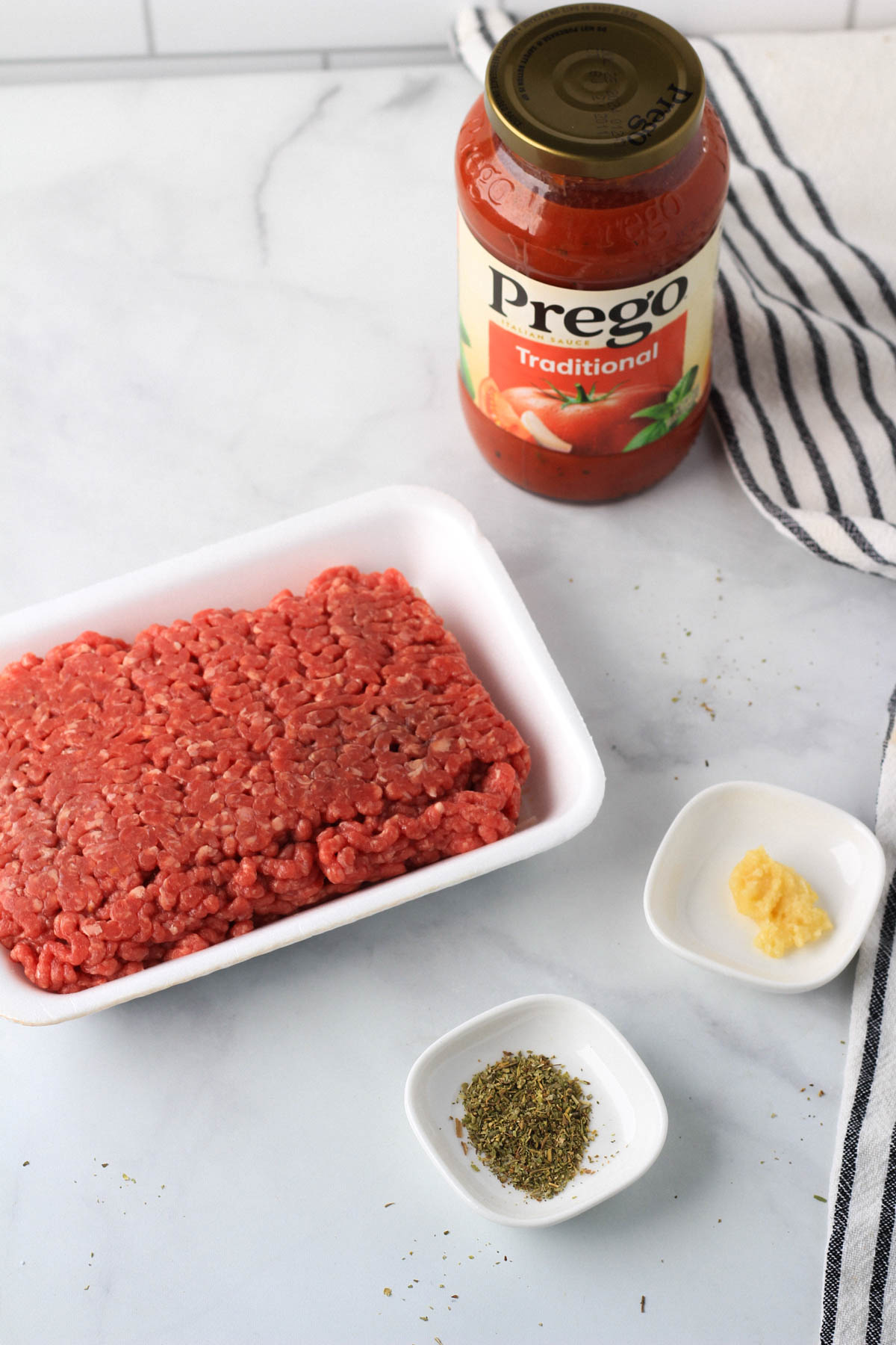 Top down picture of the ingredients for a red meat sauce.