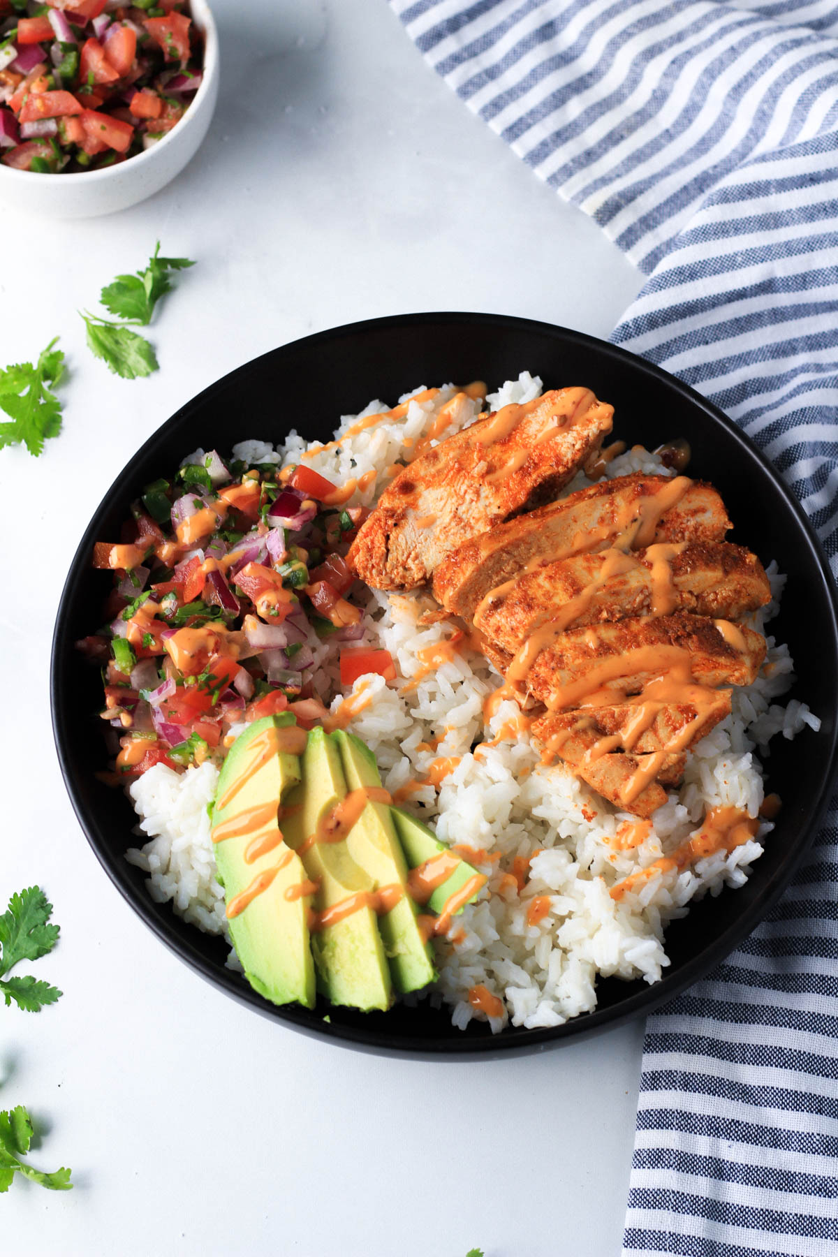 A southwest chicken burrito bowl with a drizzle of chipotle dressing on top.