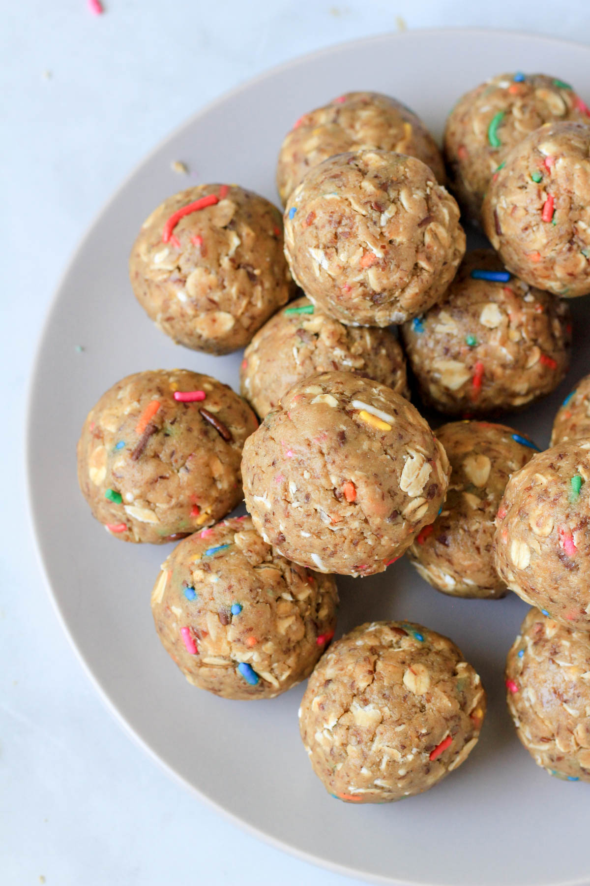 The left side of a white plate topped with rolled cake batter lactation bites.