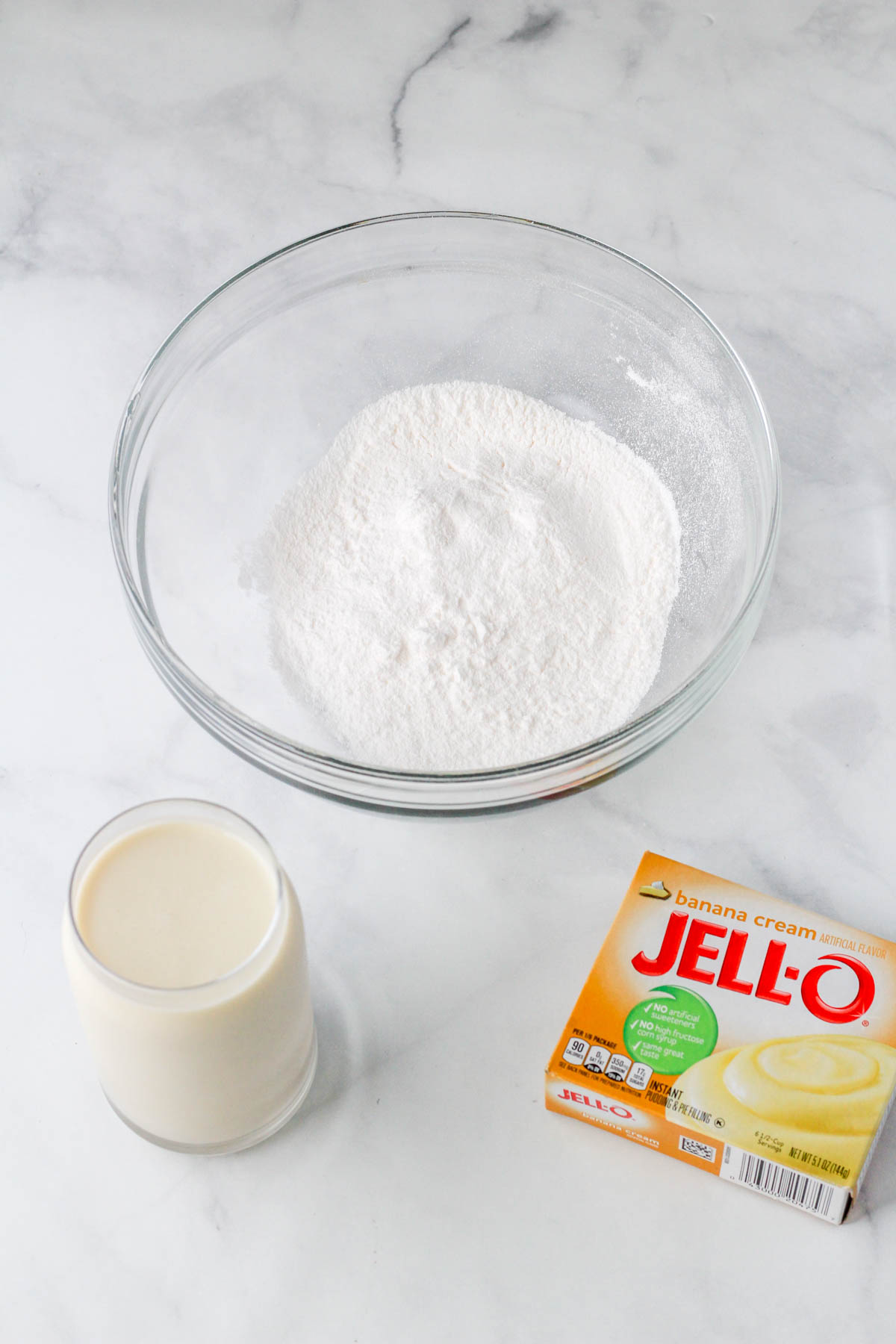 Ingredients to make instant banana cream pudding on a white counter.