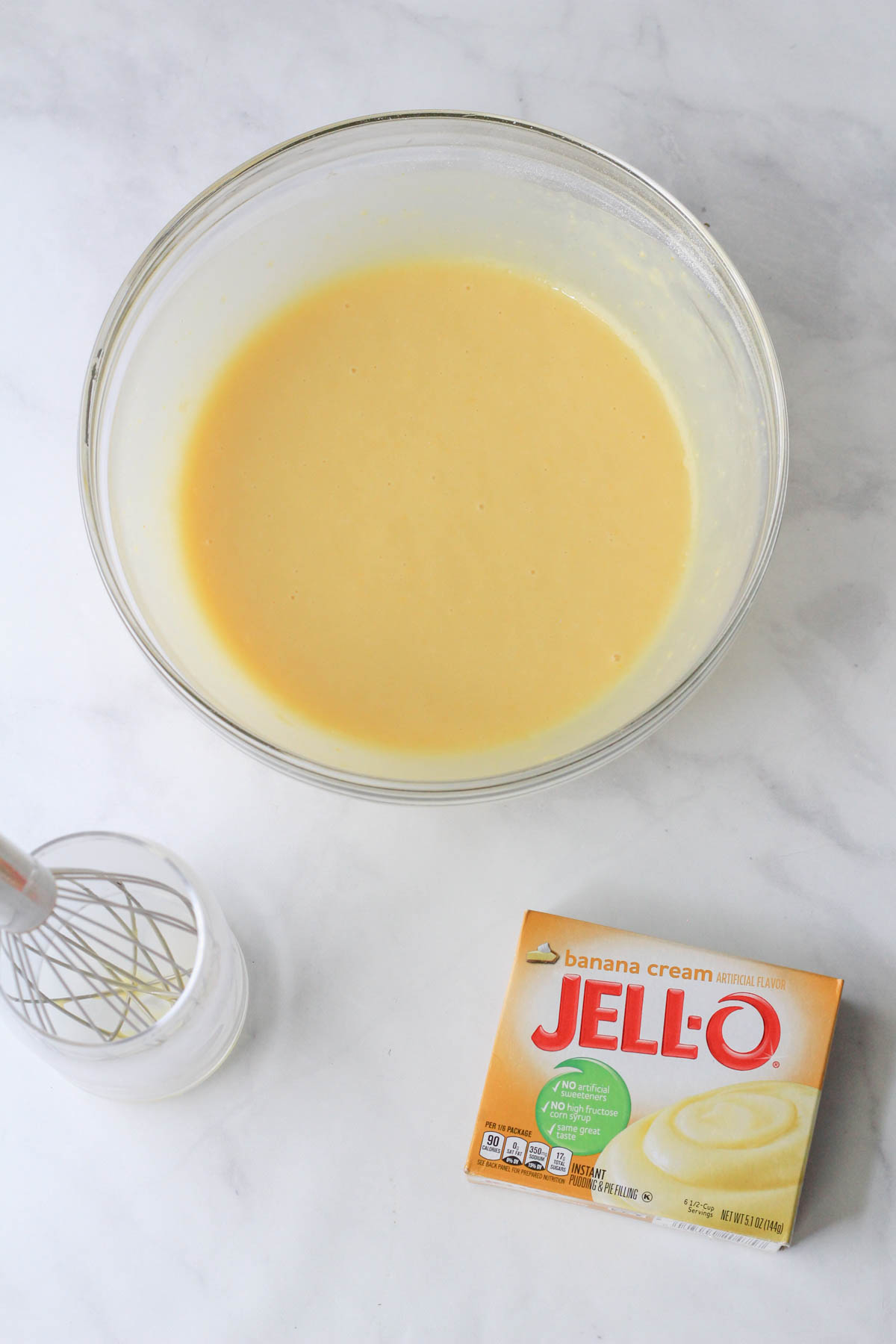 A glass bowl with banana cream instant jell-o pudding made with oat milk.