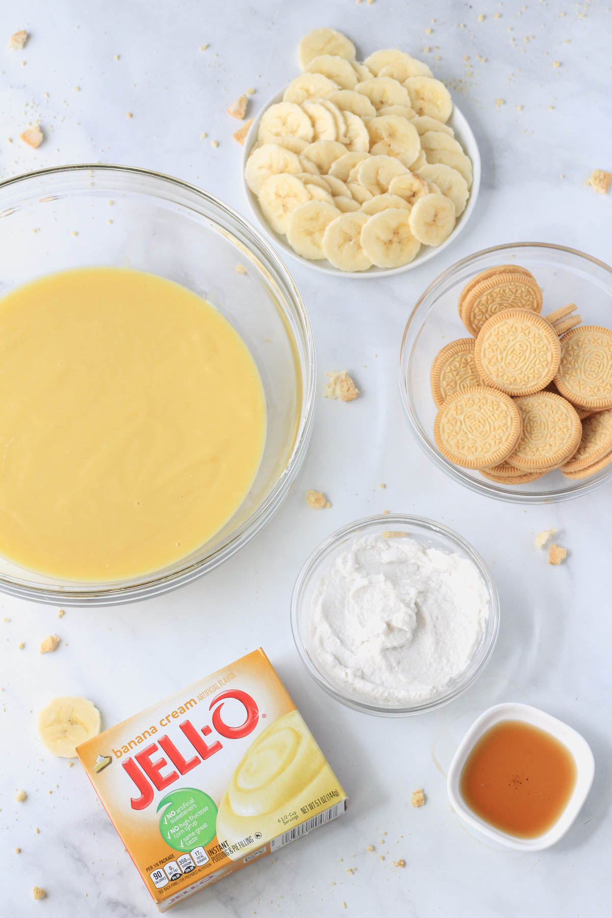 Ingredients to make banana pudding popsicles on a white counter.