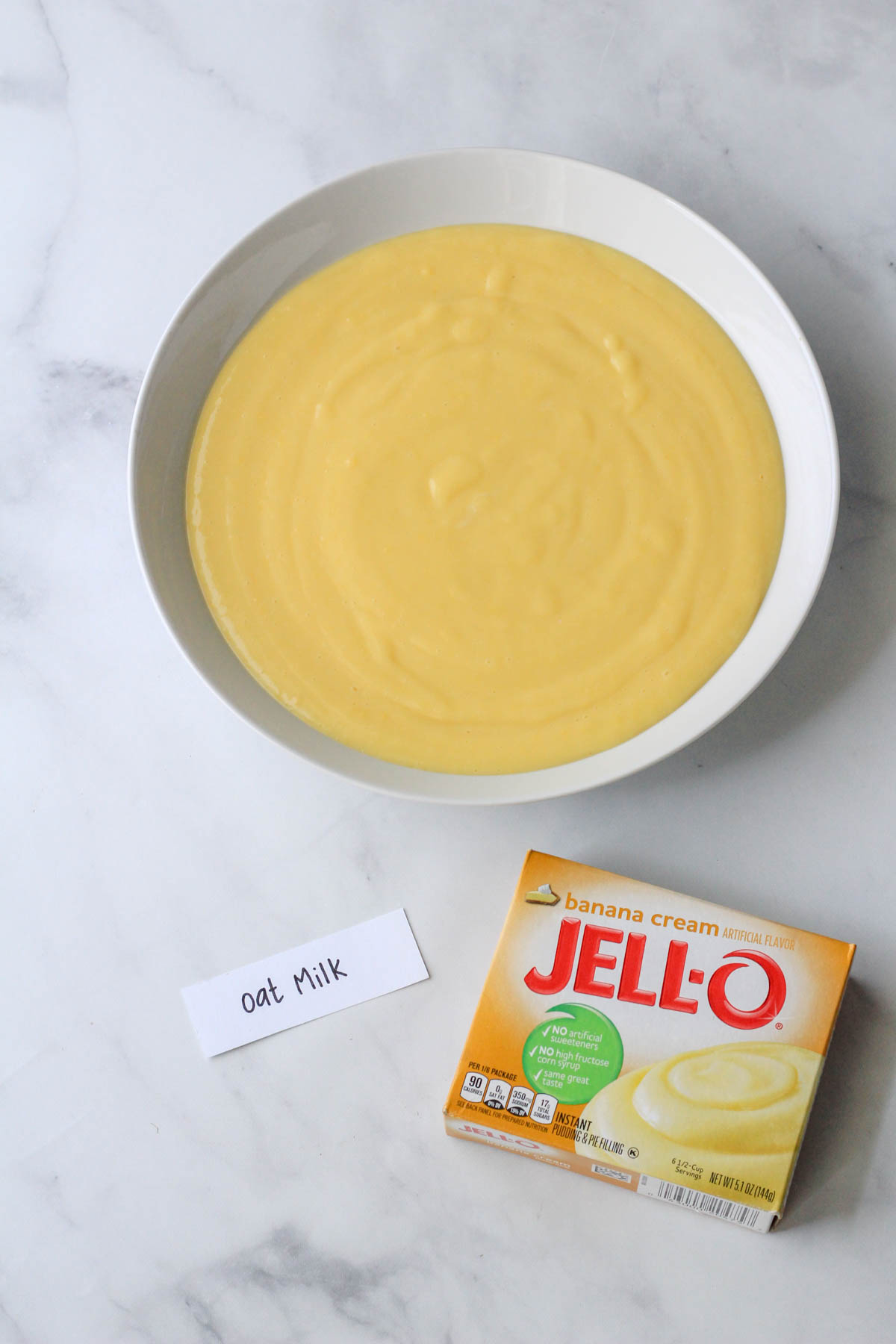 A white bowl with banana cream jell-o made with oat milk.