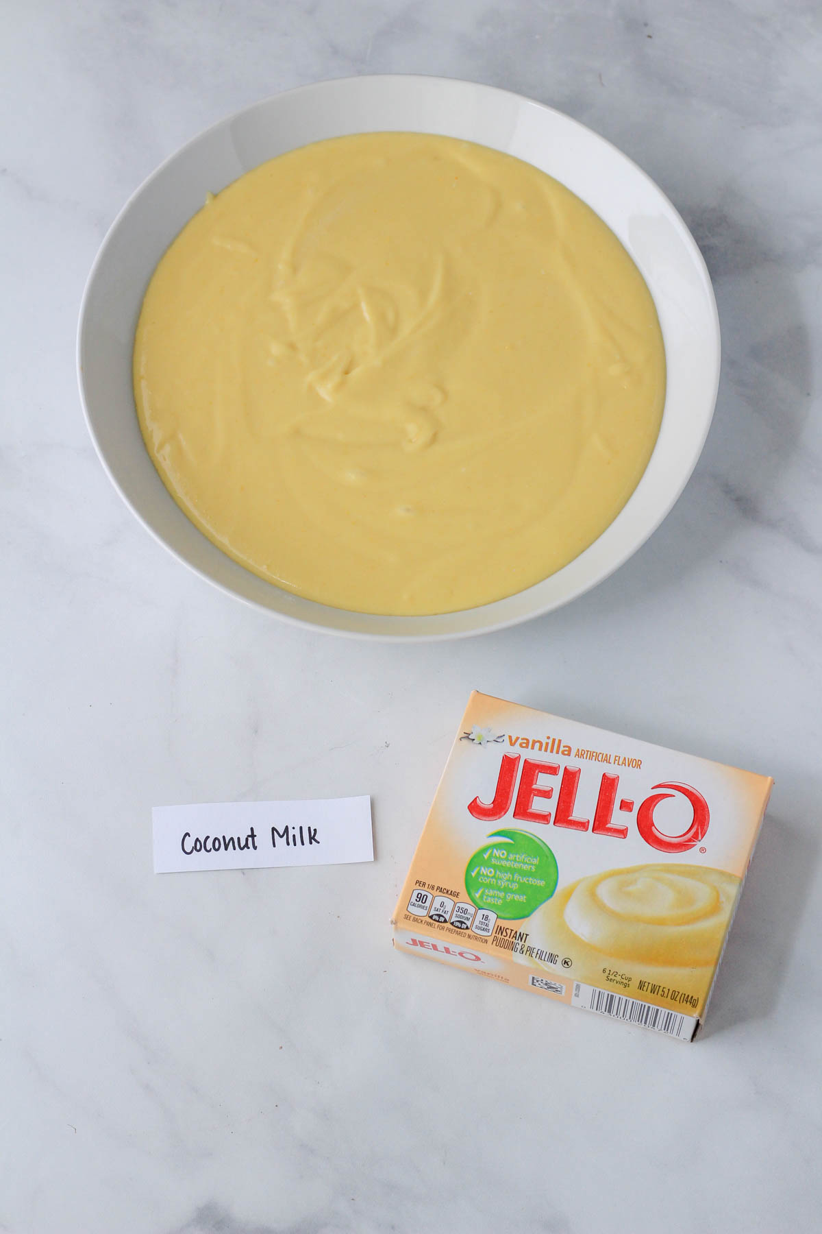 A white bowl with coconut milk based vanilla instant pudding.