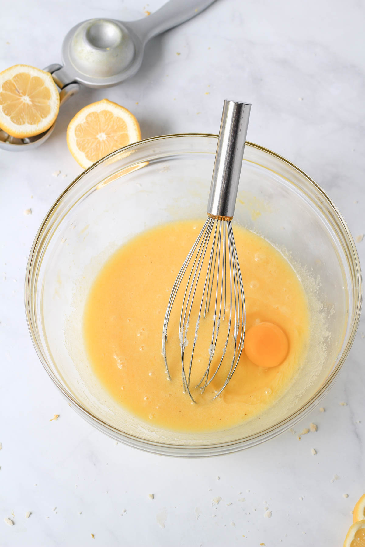 A glass mixing bowl with lemon chess pie filling before all of the eggs are mixed in.