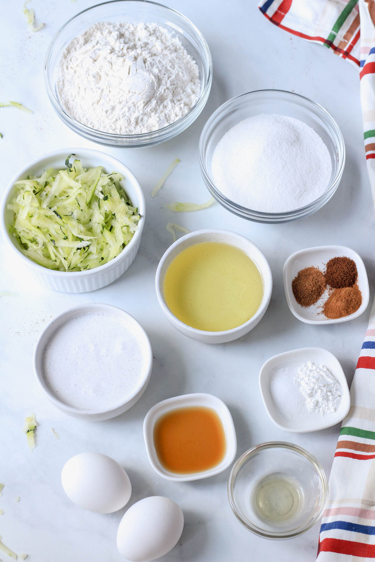 Ingredients for cinnamon swirl zucchini bread on a white counter.