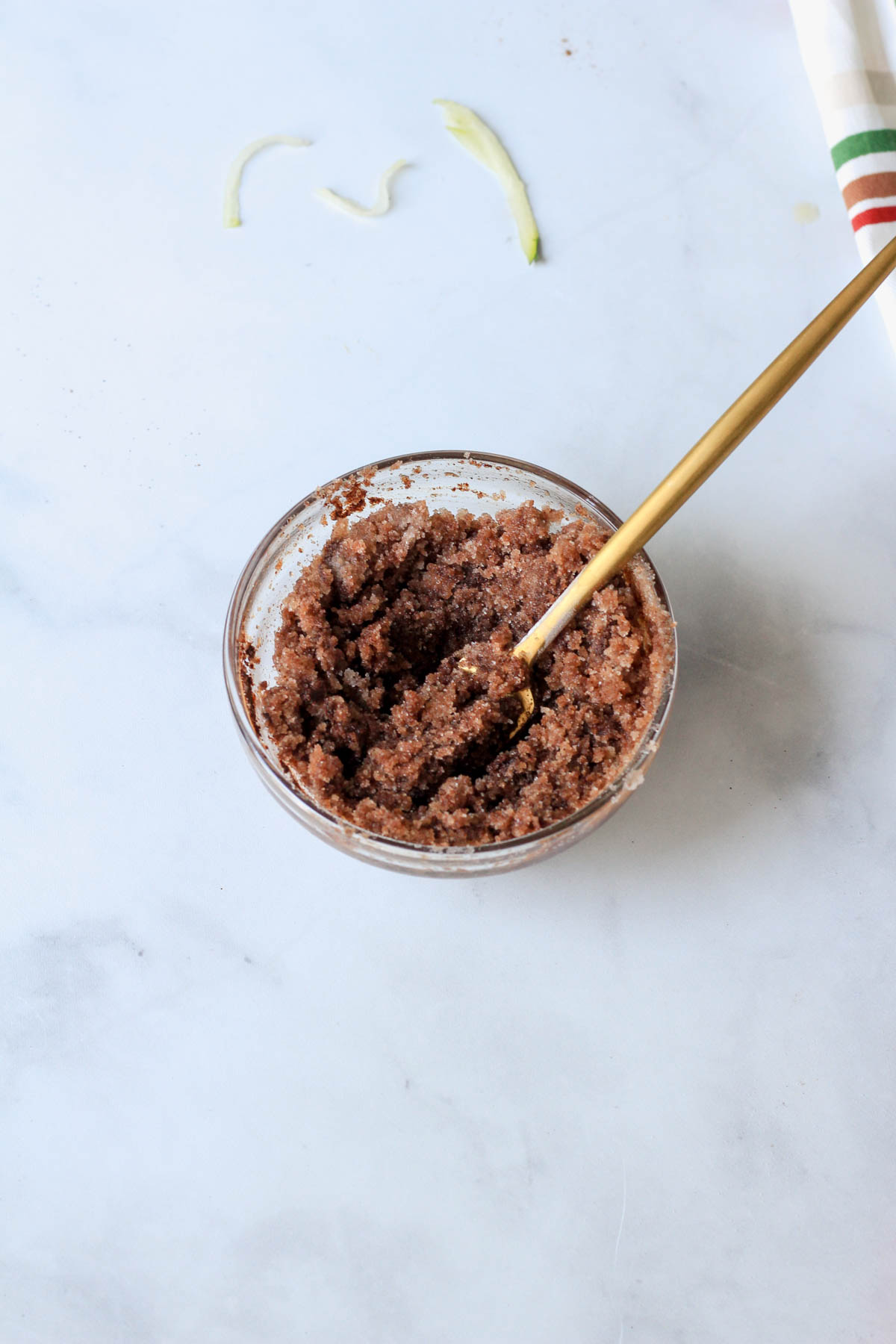 A small glass bowl with a gold fork and the cinnamon swirl topping mixed together.