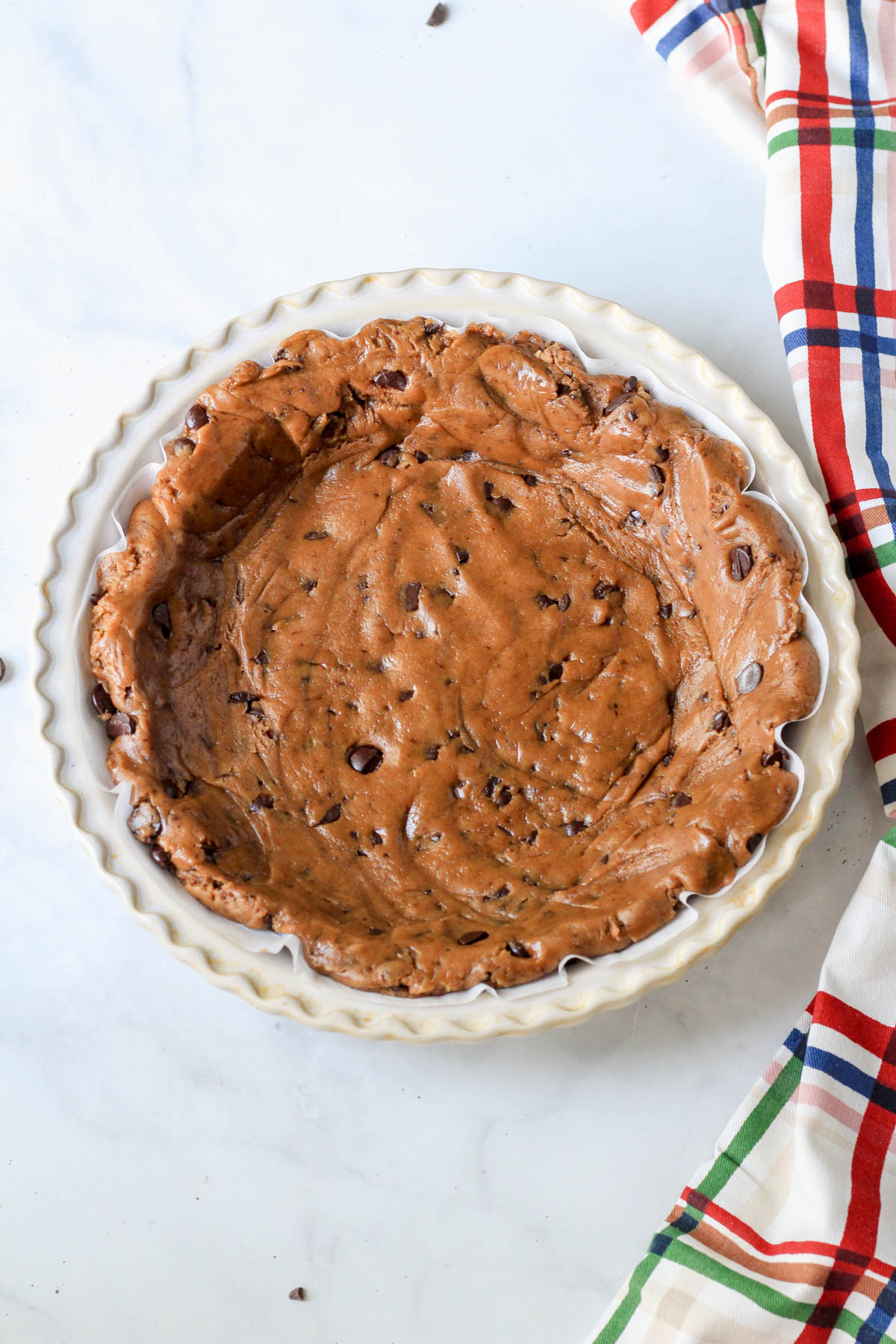A 9-inch pie pan with unbaked espresso chocolate chip cookie dough pressed into the pan.