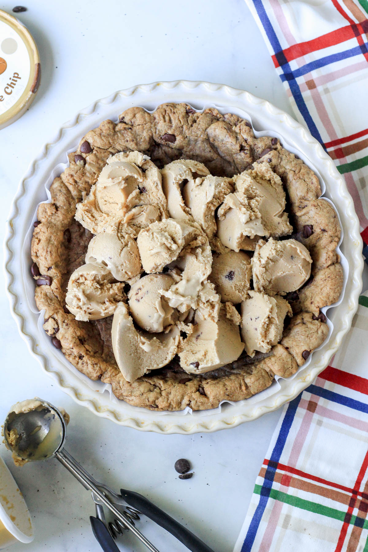 A pie pan with espresso chocolate chip cookie crust topped with scoops of dairy-free coffee chip ice cream.