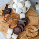 A close up of a dairy-free s'mores board including different chocolate, marshmallows, and graham crackers.