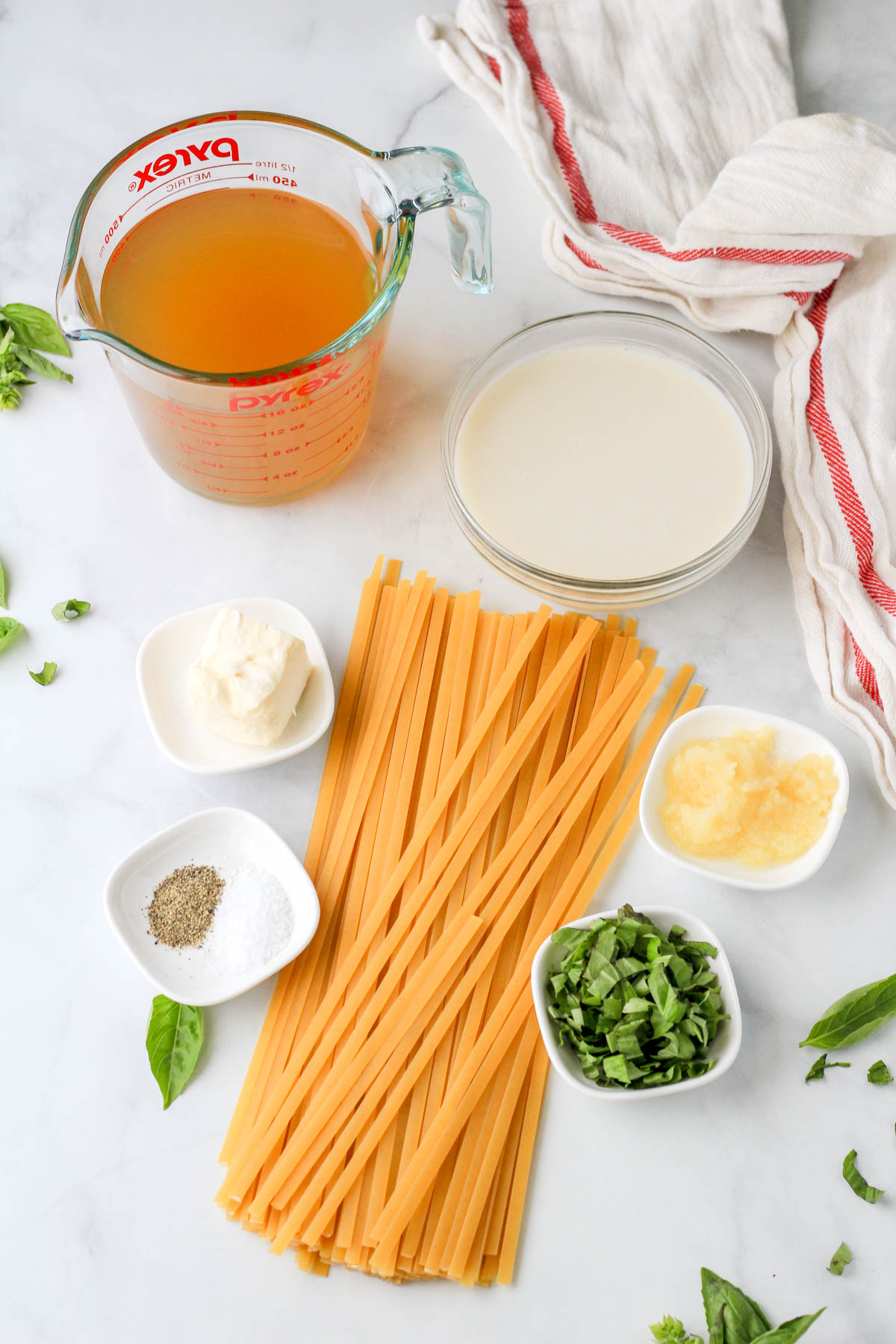 Ingredients for vegan one pot garlic pasta on a white counter.