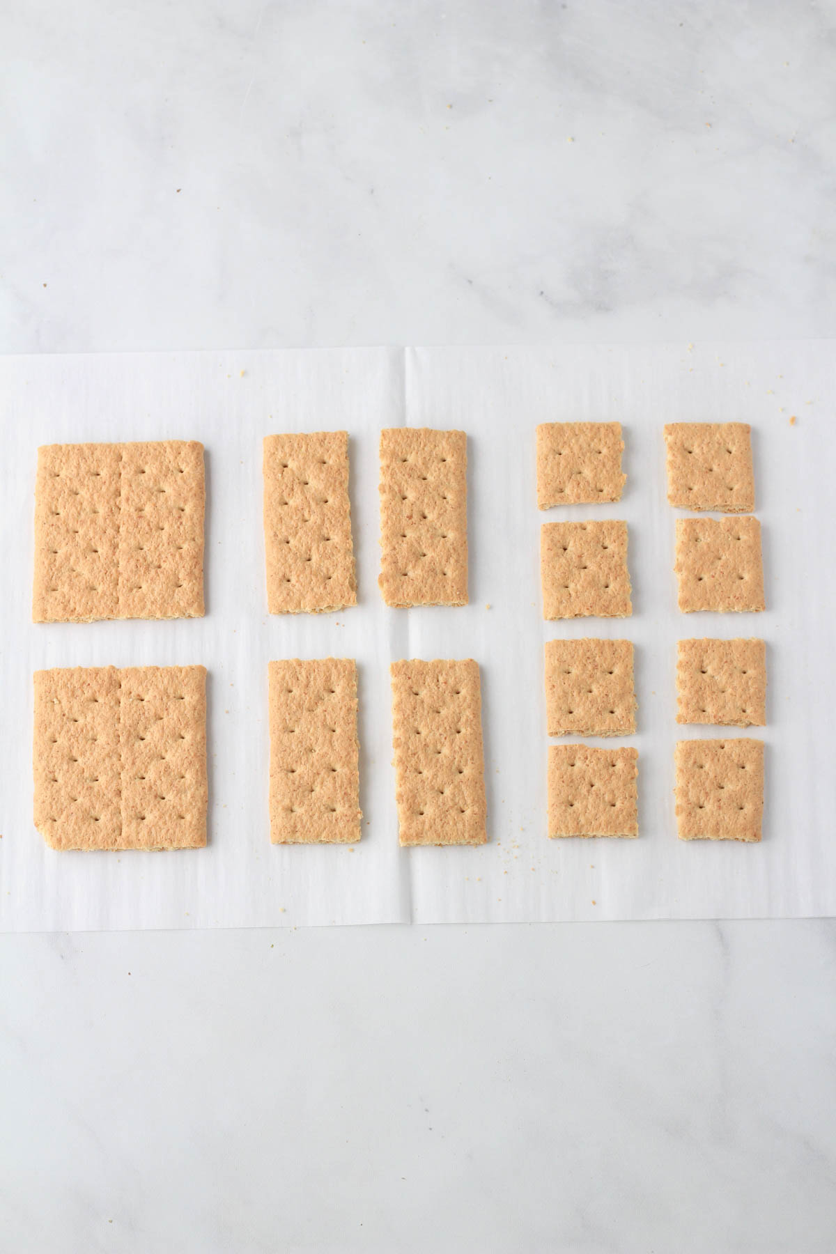 A white parchment paper with graham crackers cut into 8 smaller squares.