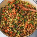 A close up of cooked turkey taco and sweet potato skillet with a wooden spoon.