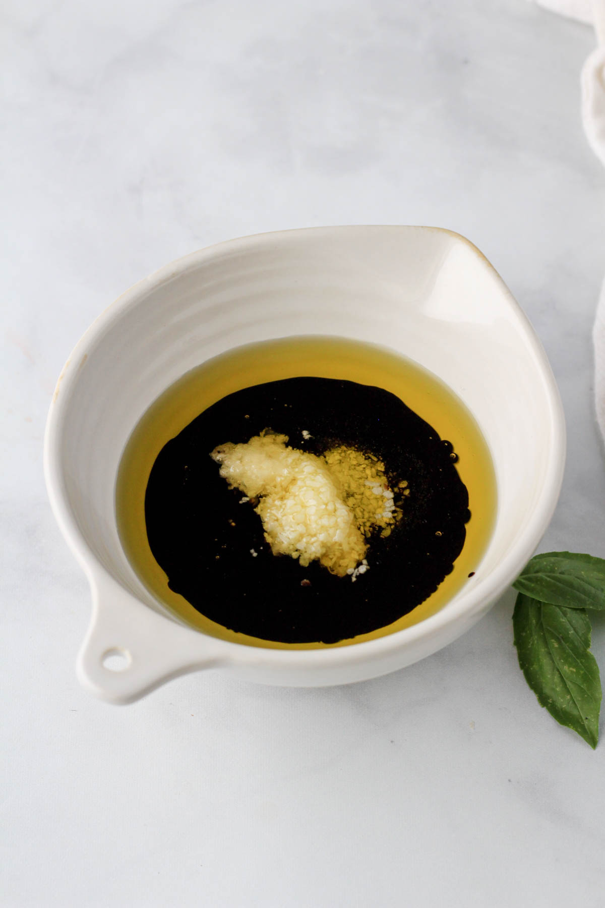 A small cream bowl with the dressing ingredients before mixing together.
