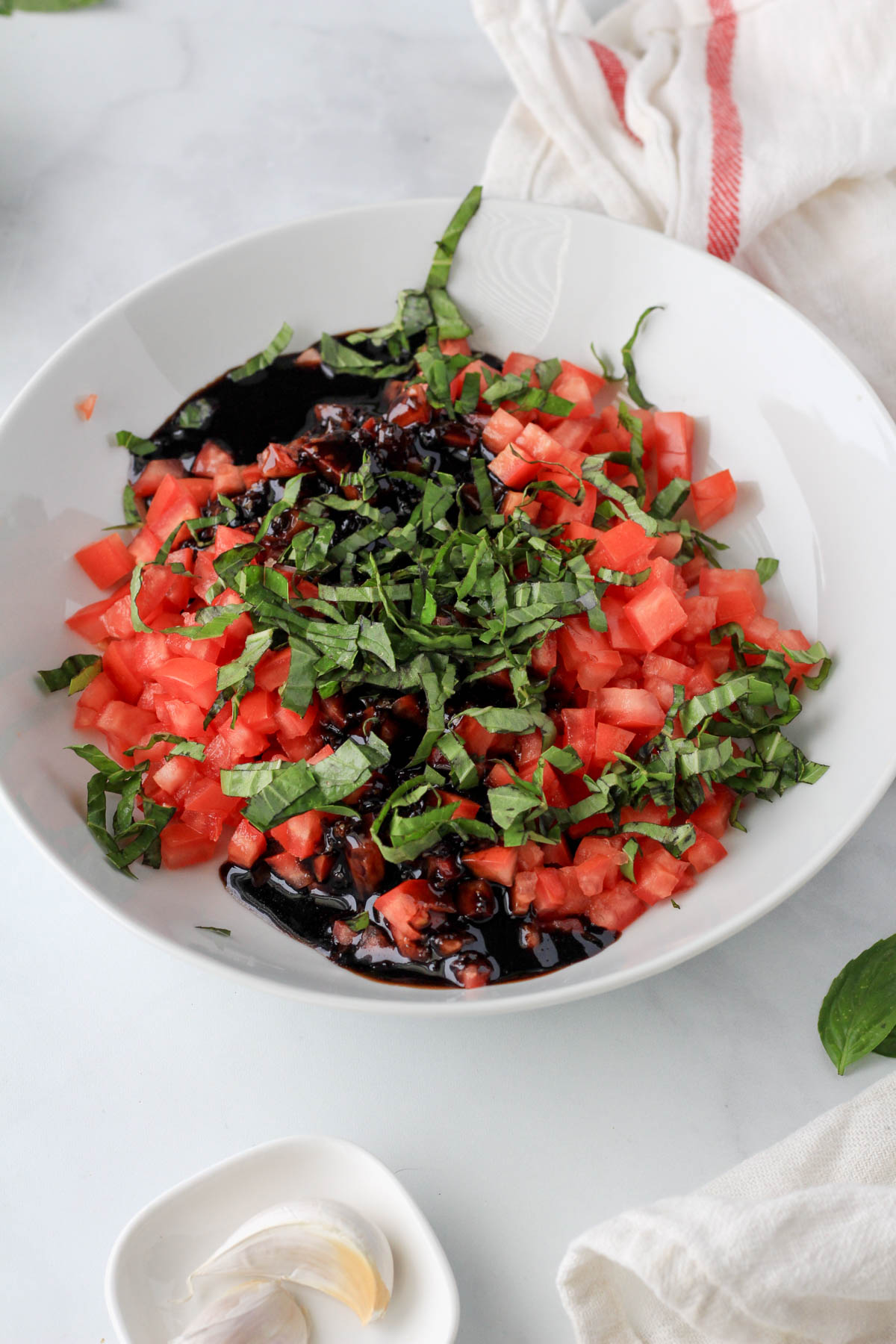 A large white bowl with the bruschetta topping before mixing together.
