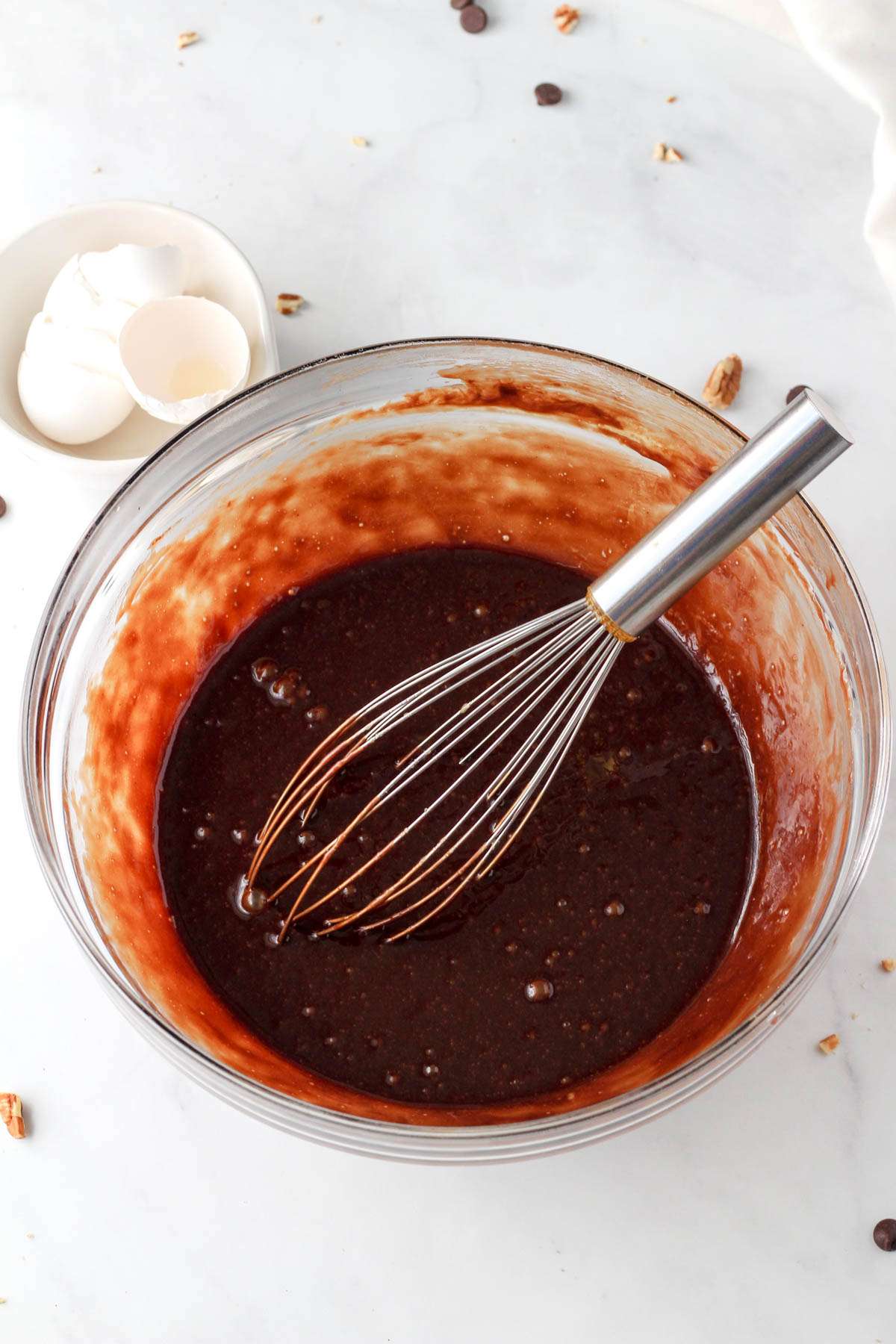 A glass mixing bowl with chocolate pecan pie filling before adding the pecans in.