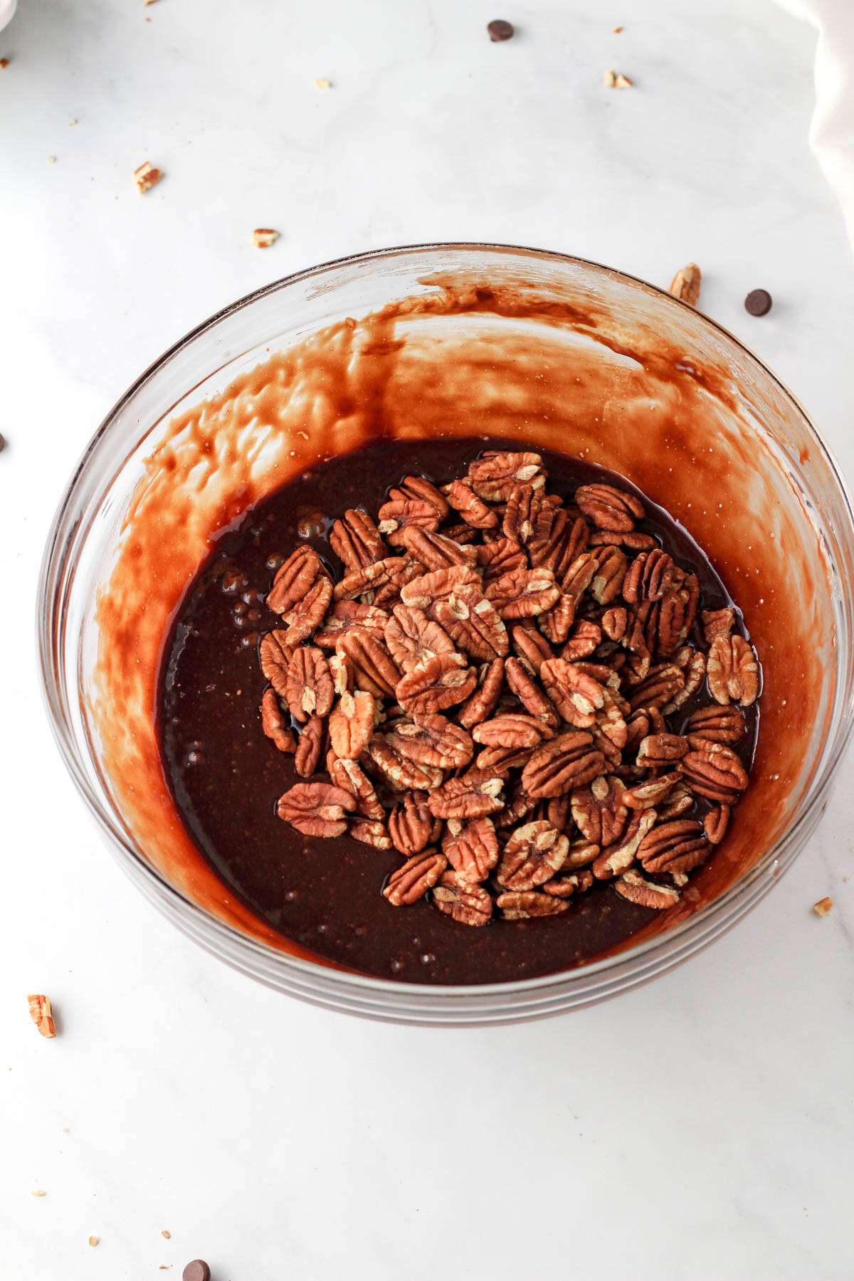 A glass mixing bowl with chocolate pecan pie filling before mixing the pecans.