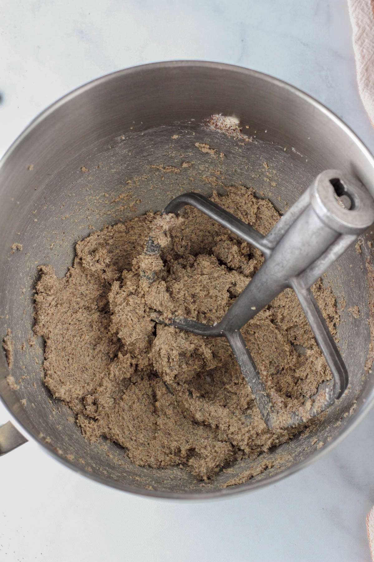 A silver mixing bowl with dairy-free butter beat with sugar and espresso.