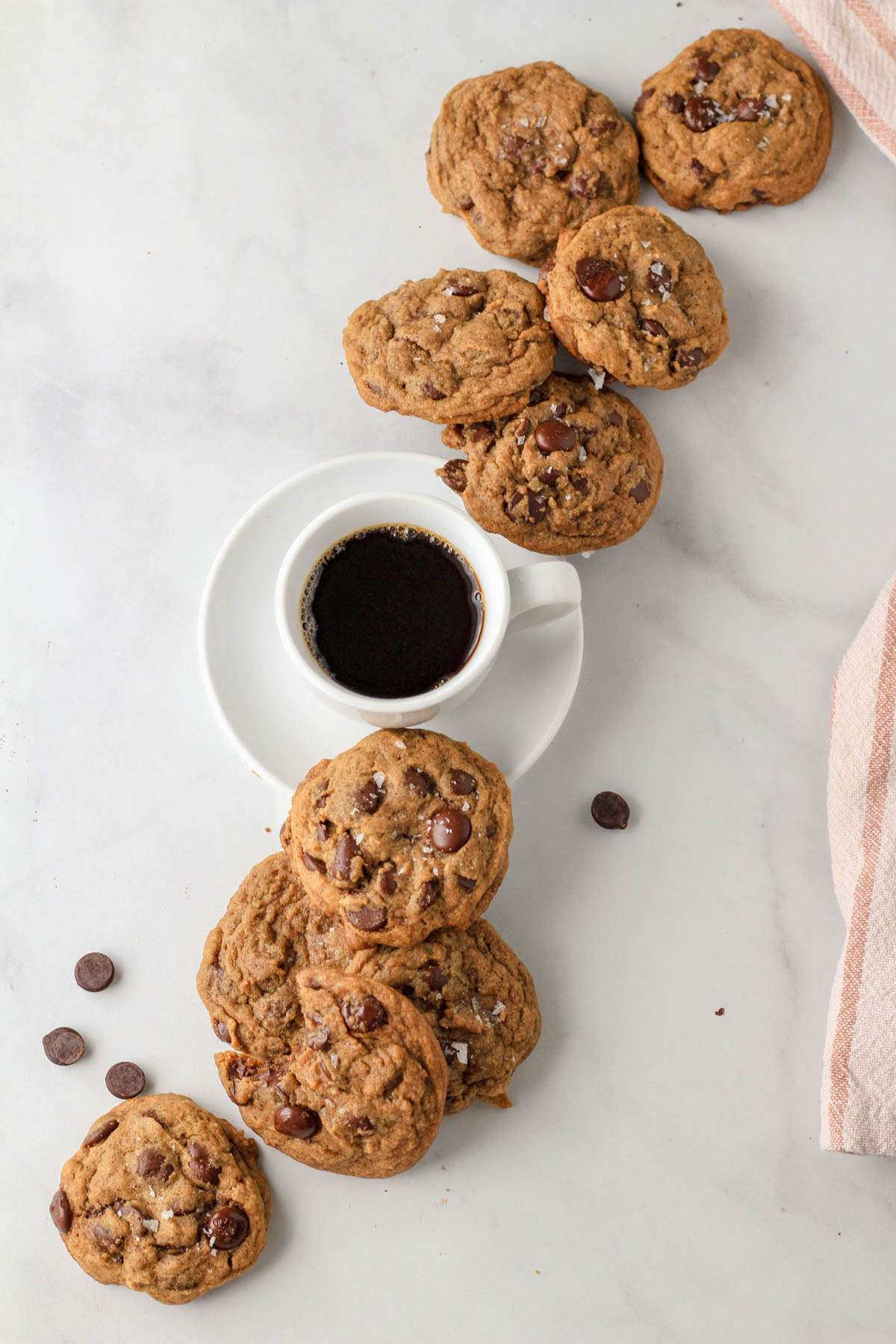 A line of espresso chocolate chip cookies with a small cup of espresso in the middle.