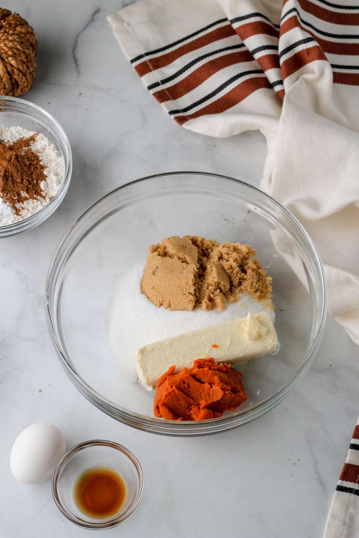 A glass bowl with the sugar and wet ingredients for the pumpkin spice cookie bars before mixing.