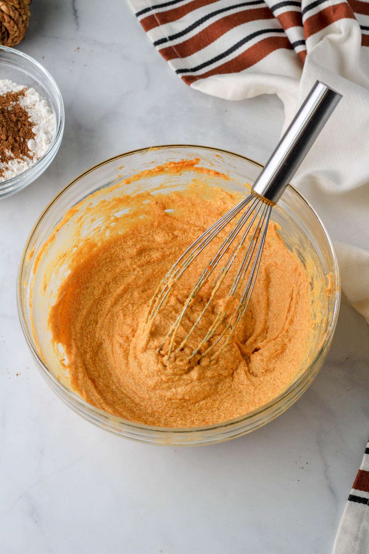 A glass bowl with pumpkin spice cookie dough after mixing in eggs and vanilla.