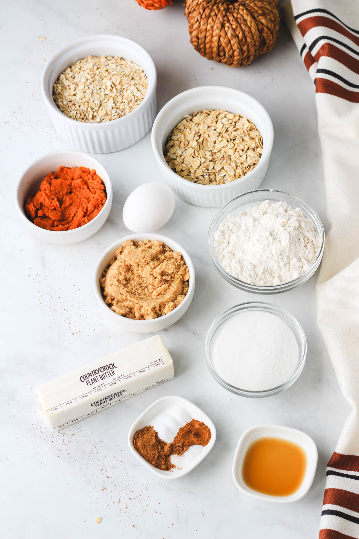 Ingredients for pumpkin spice oatmeal cream pies on a white counter.