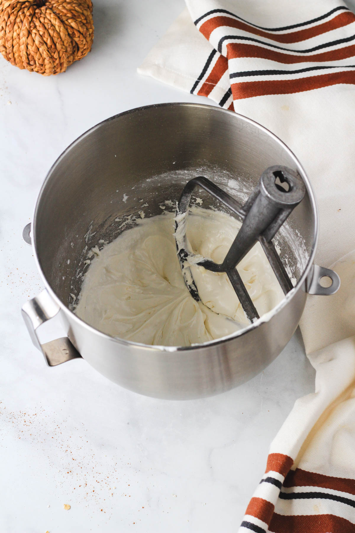 A silver mixing bowl with dairy-free marshmallow fluff frosting after mixing.