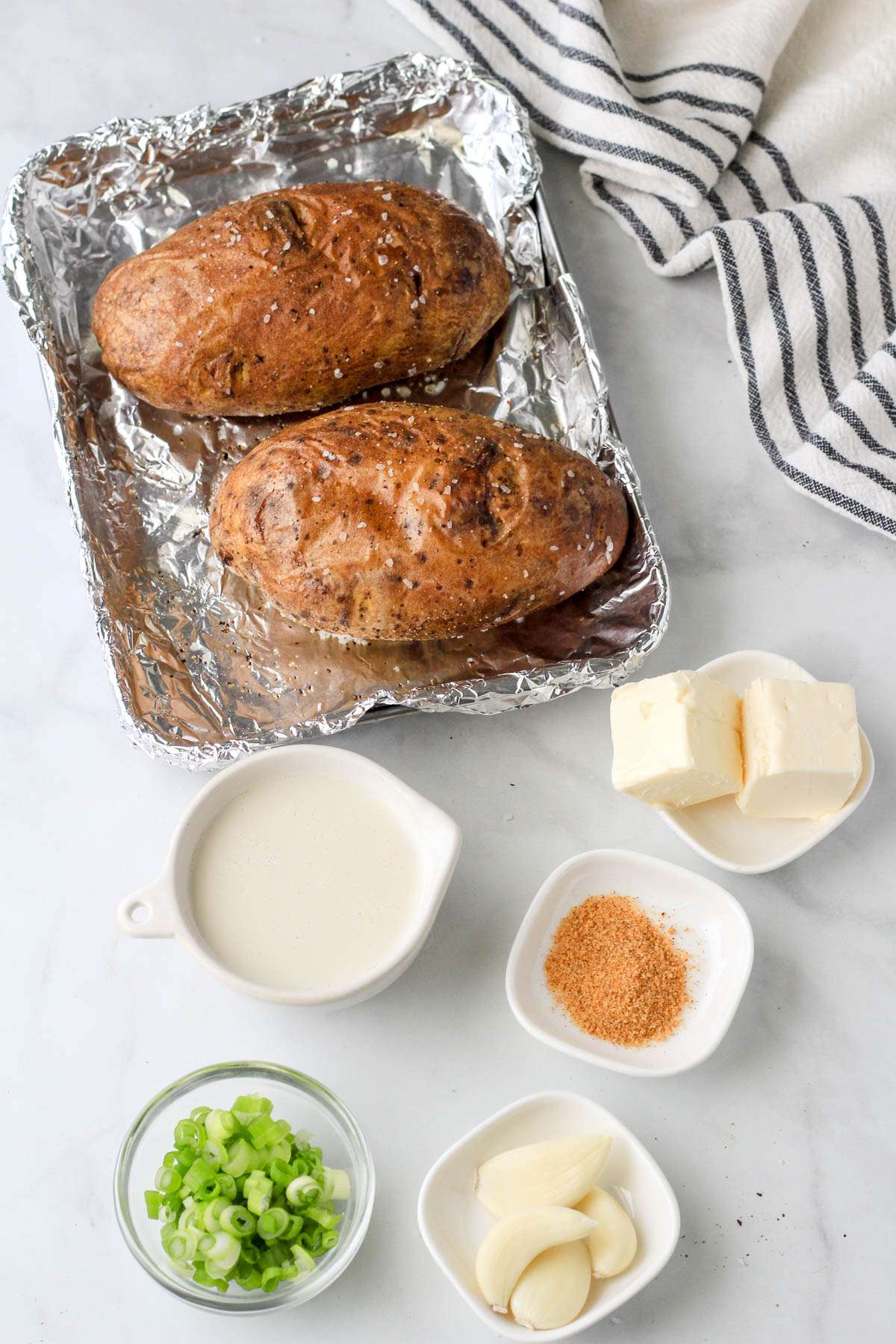 Ingredients for vegan twice baked potatoes on a white counter.