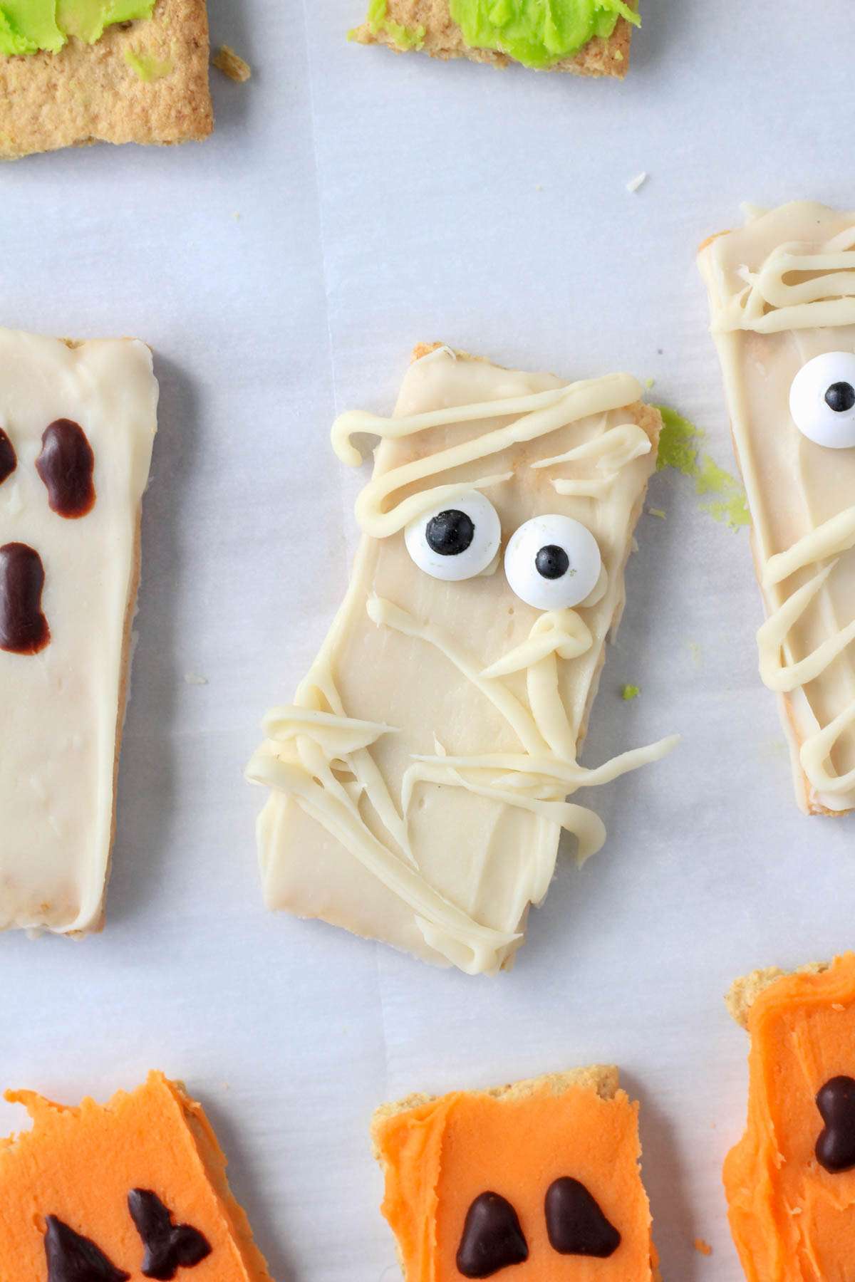 A white chocolate dipped graham cracker decorated to look like a mummy.